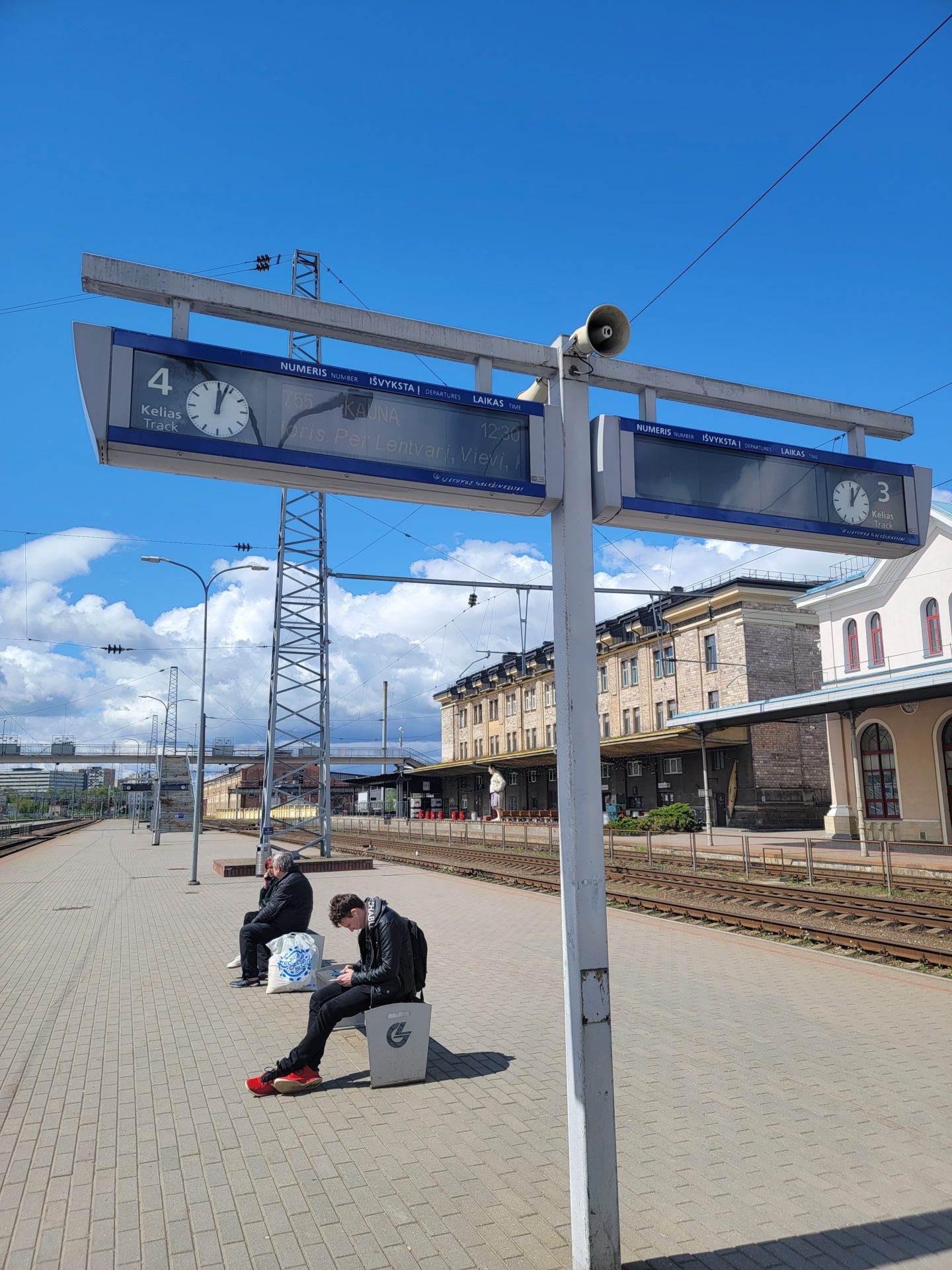 a man sitting on a platform next to a sign