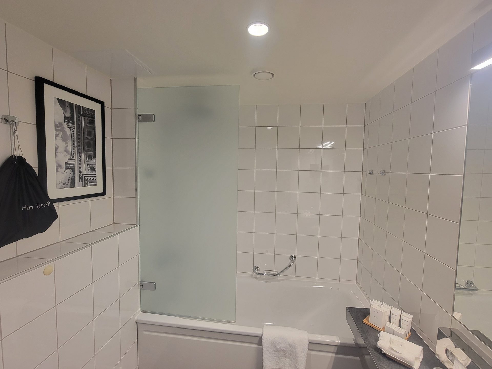 a bathroom with a bathtub and a picture