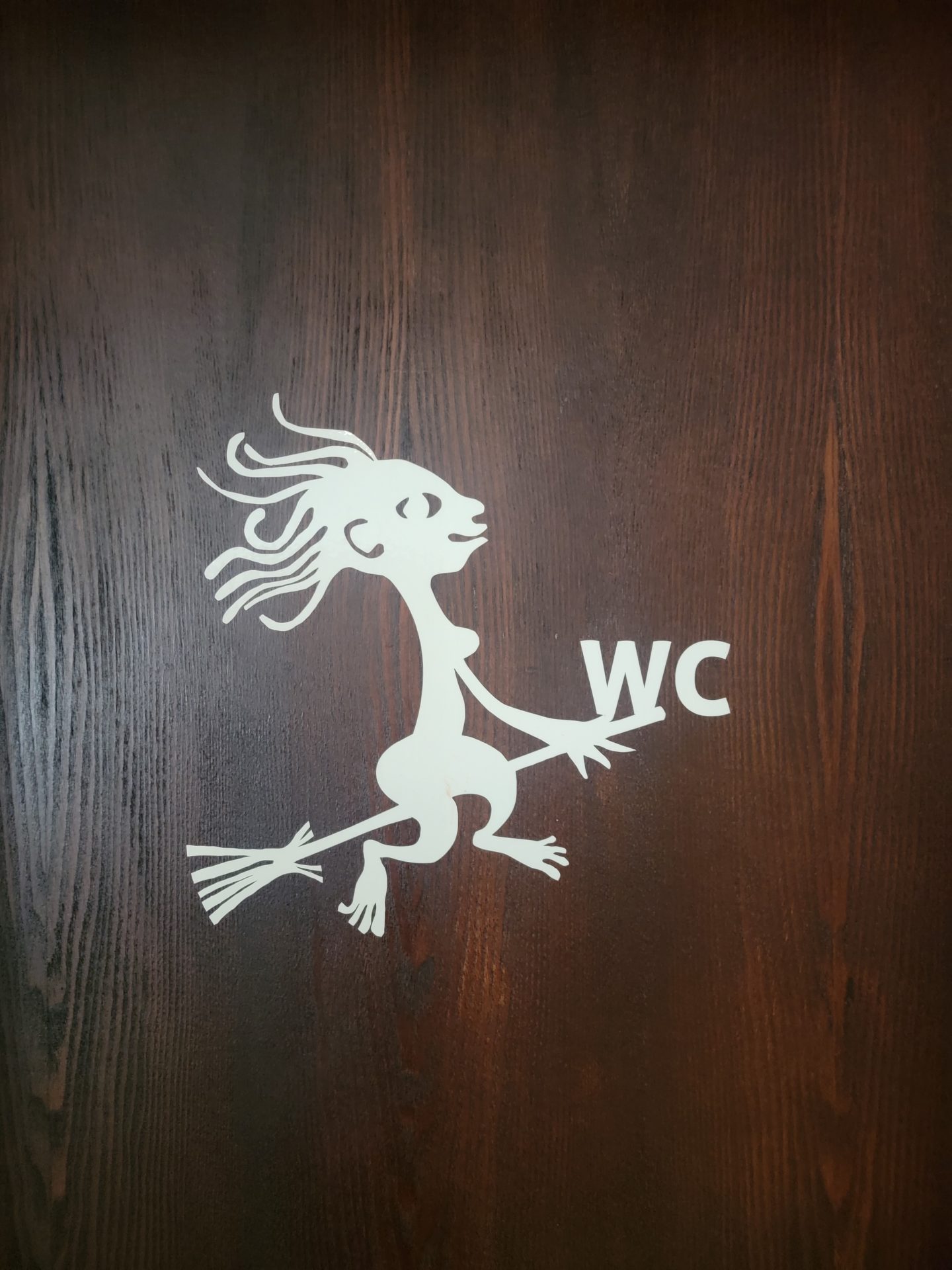 a white paper cut out of a woman on a wooden surface