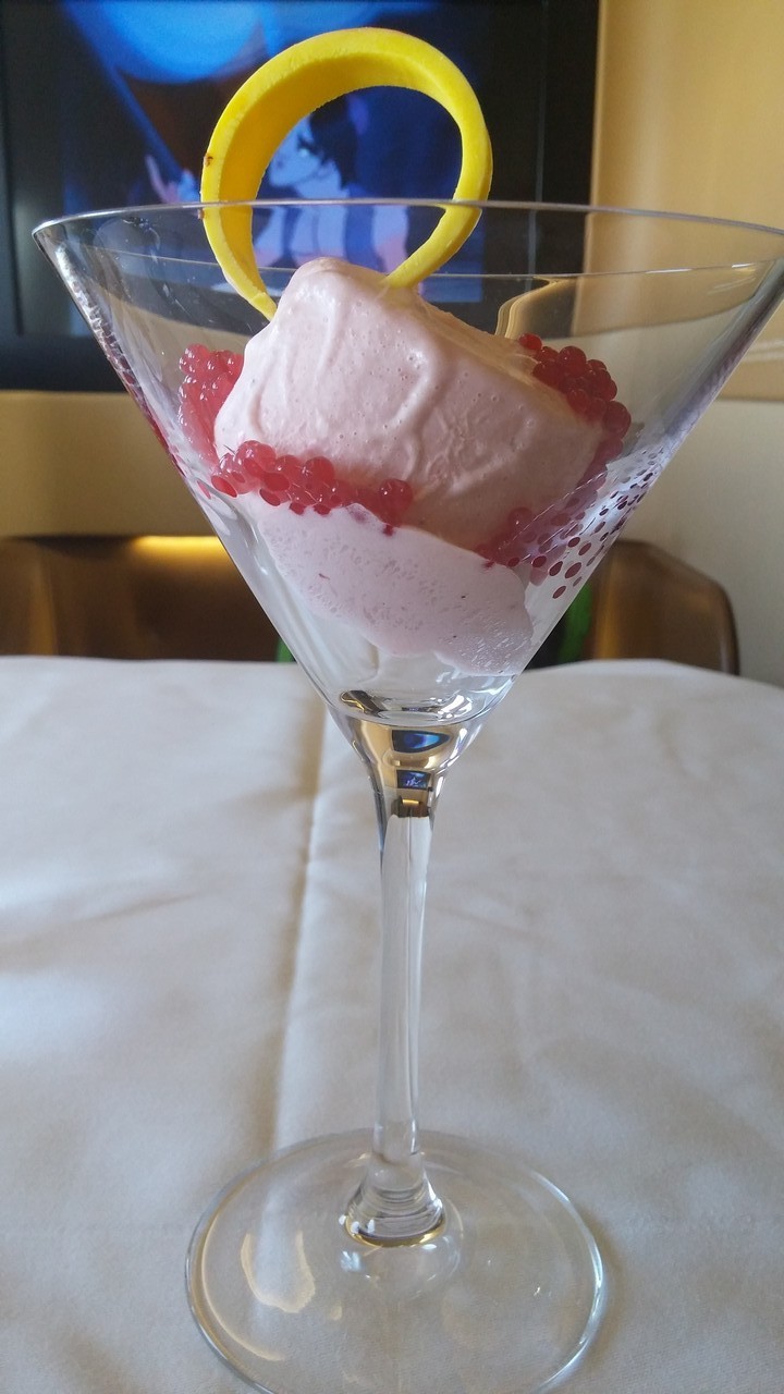 a glass with a pink and white dessert in it