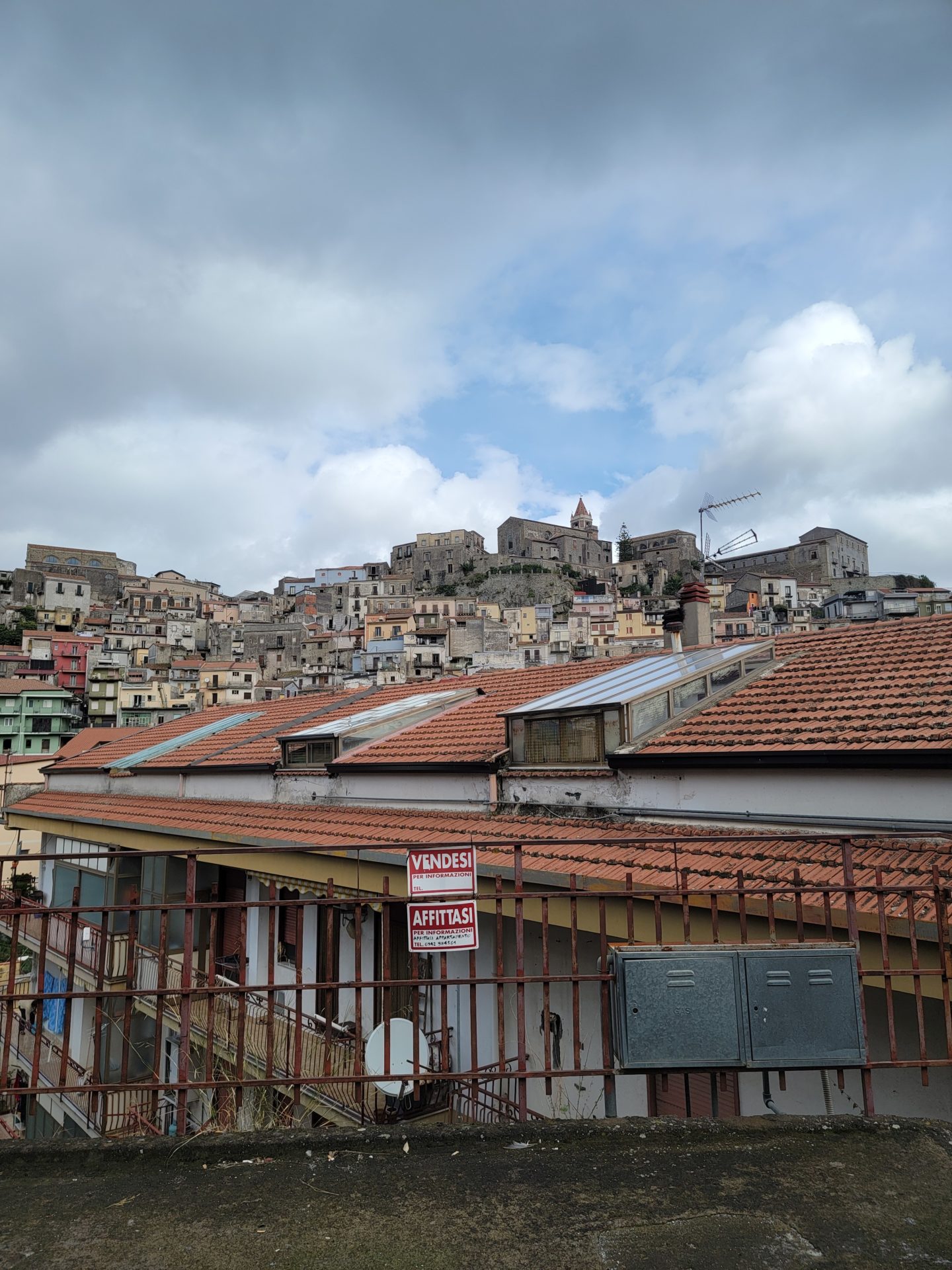 a group of buildings with a hill in the background