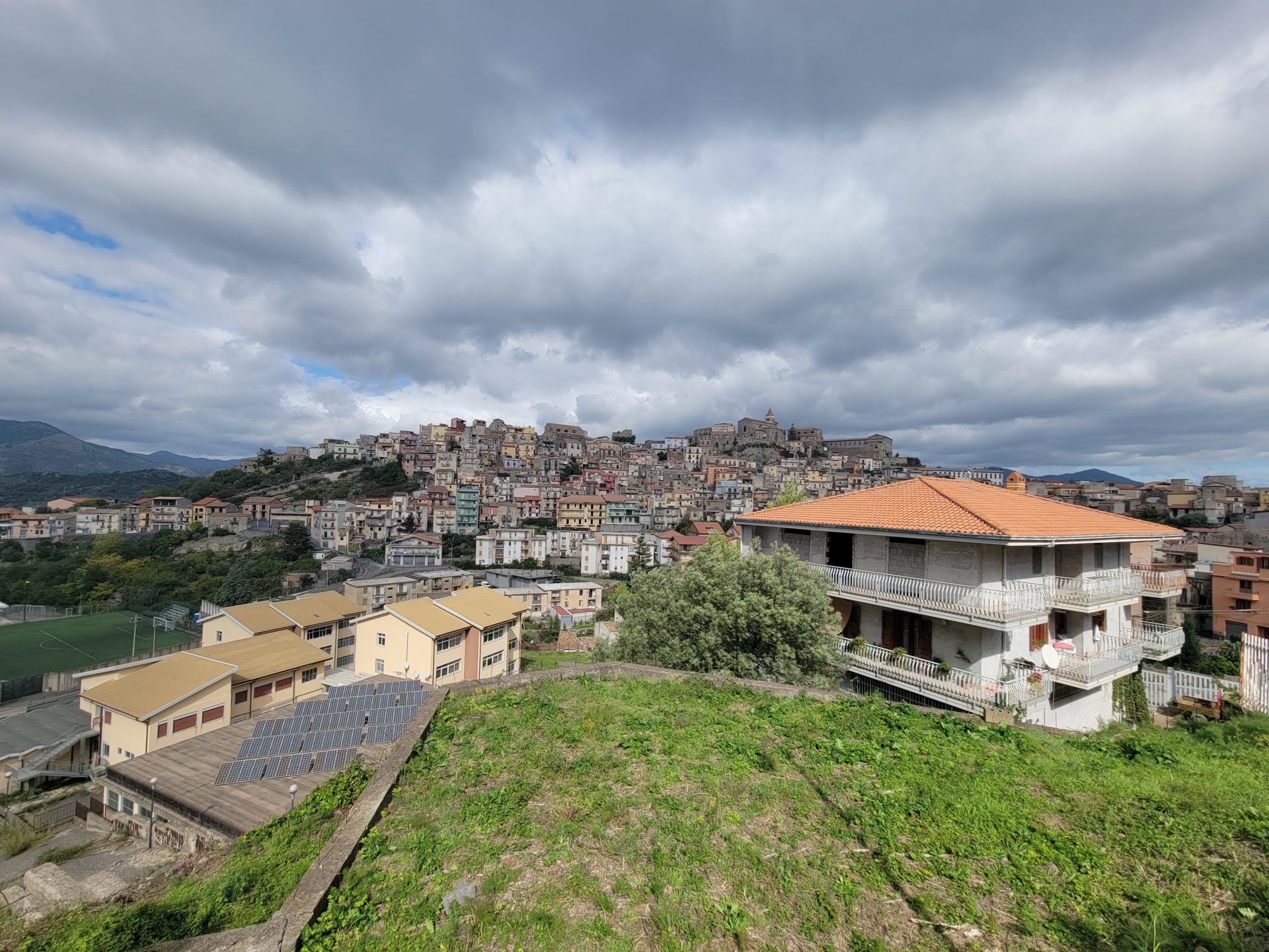 a hill with buildings and a city in the background