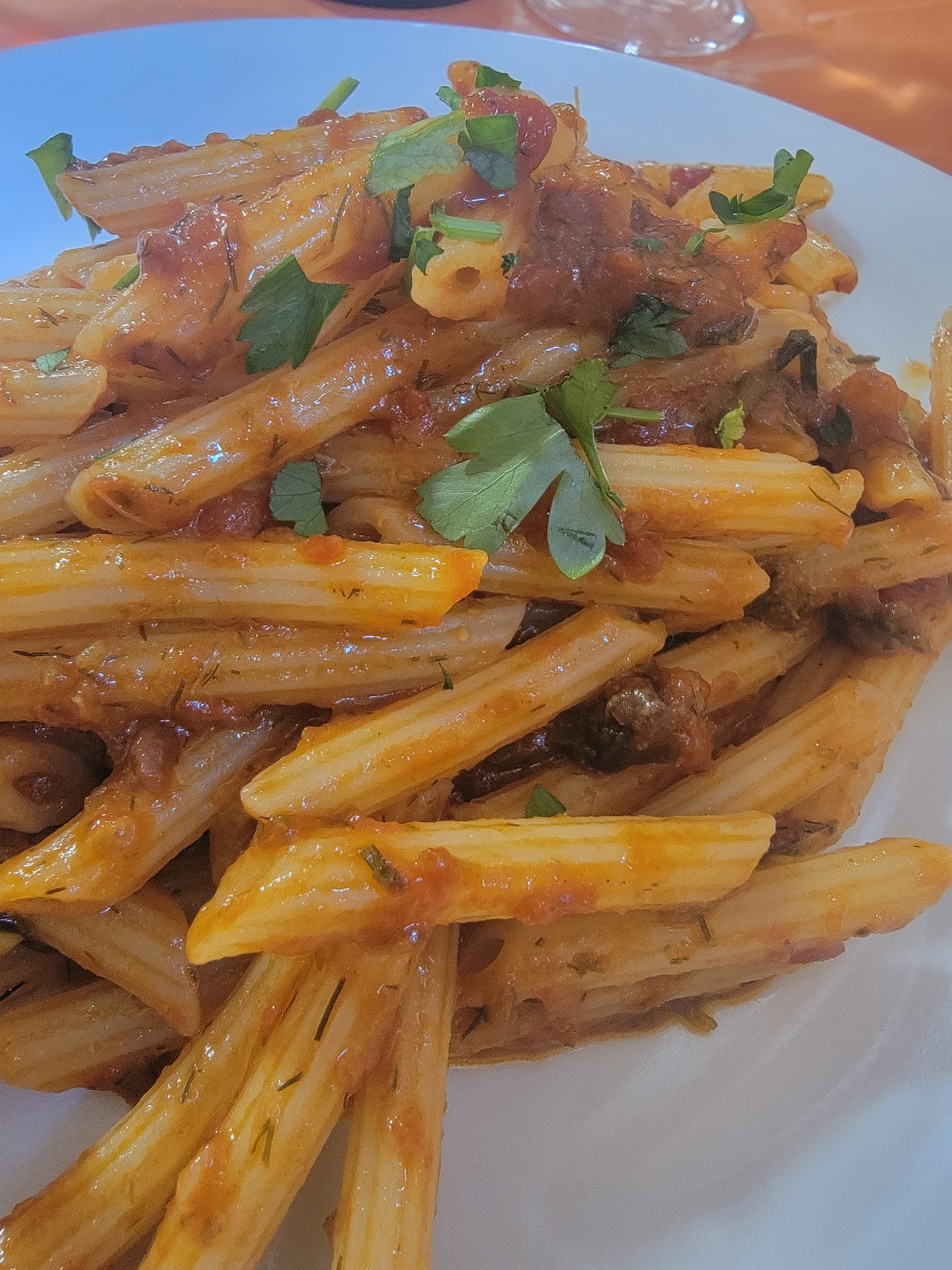 a plate of pasta with sauce and parsley