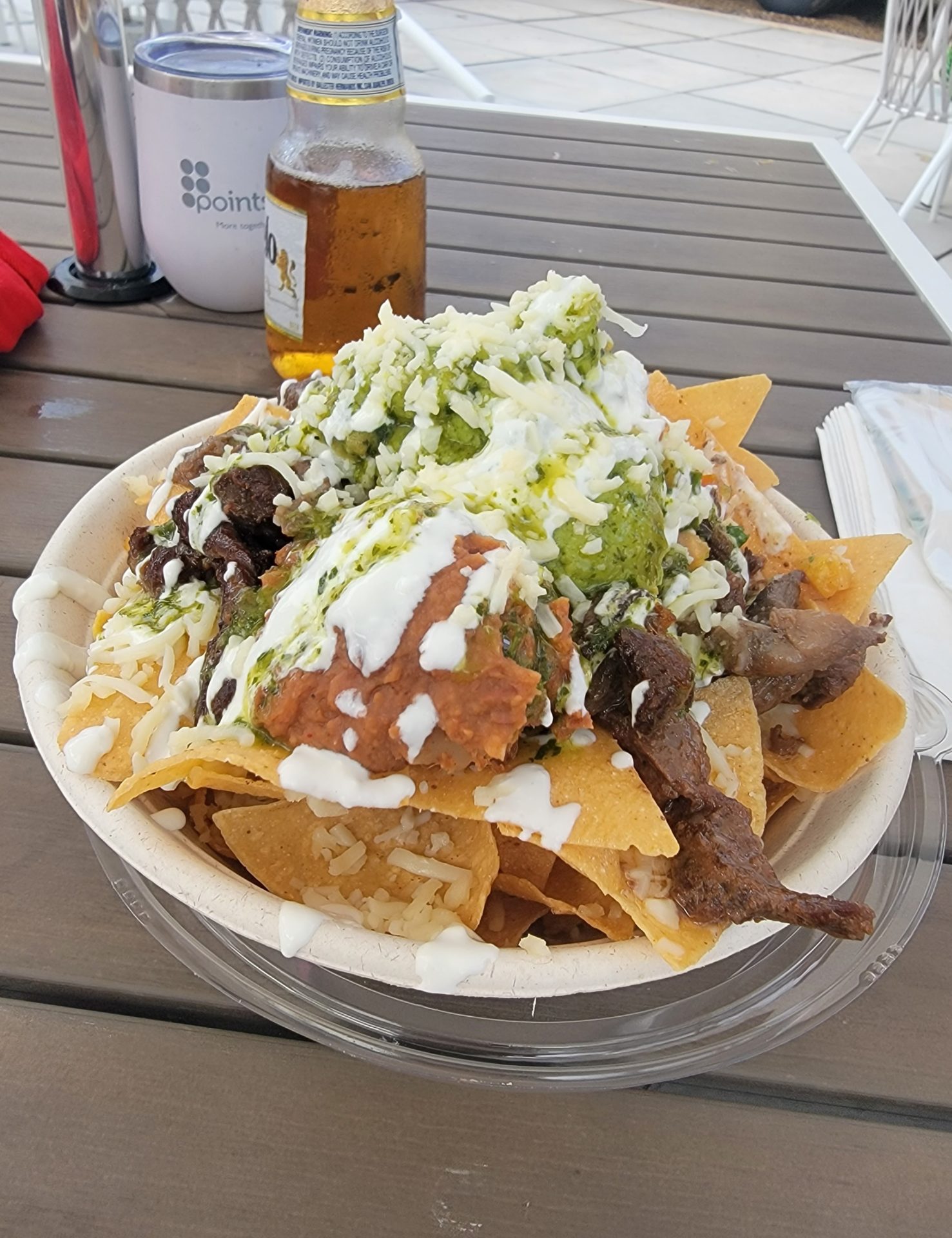 a bowl of nachos with meat and cheese
