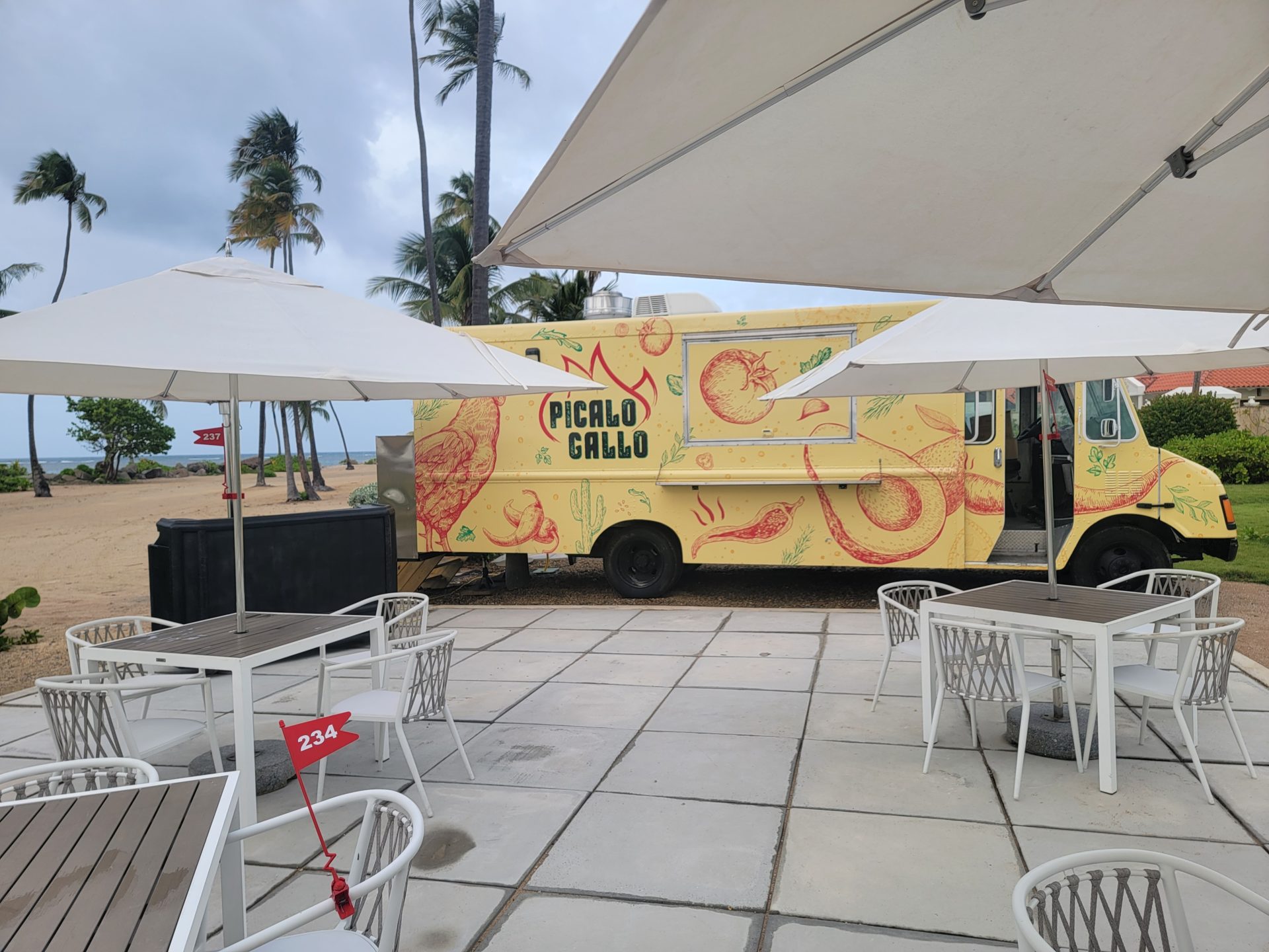 a food truck parked outside with tables and chairs
