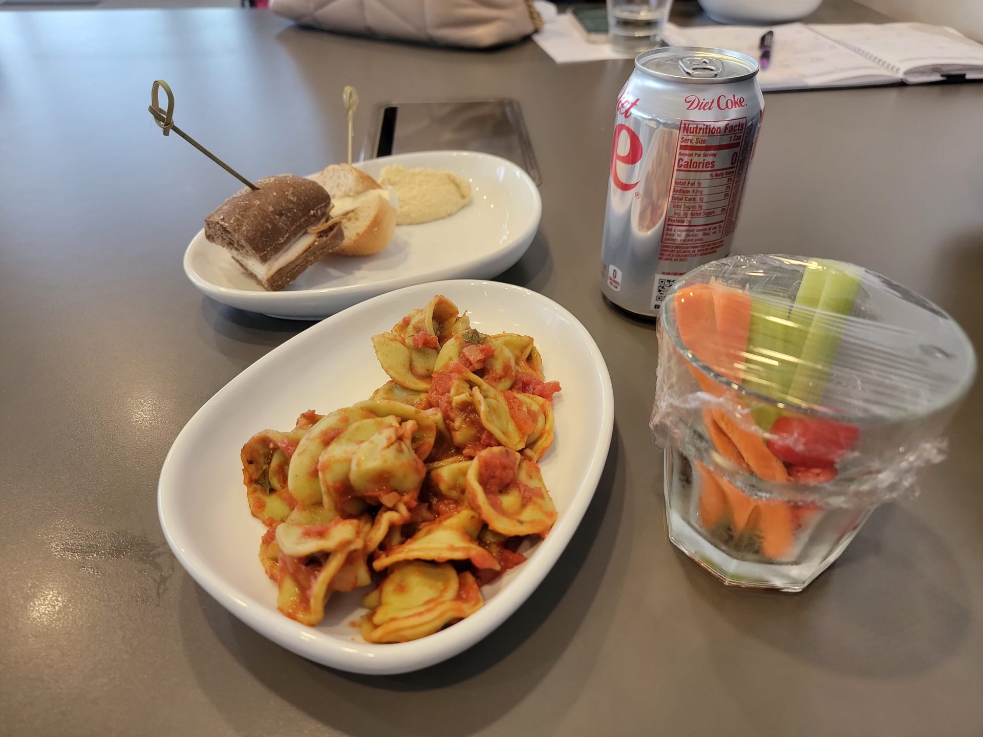 a plate of food and a soda on a table