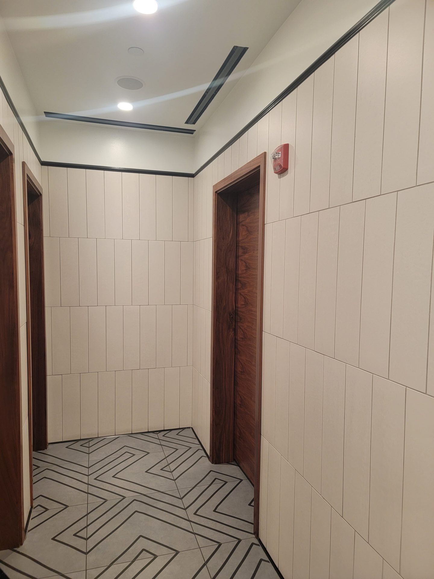 a hallway with a door and a tile floor