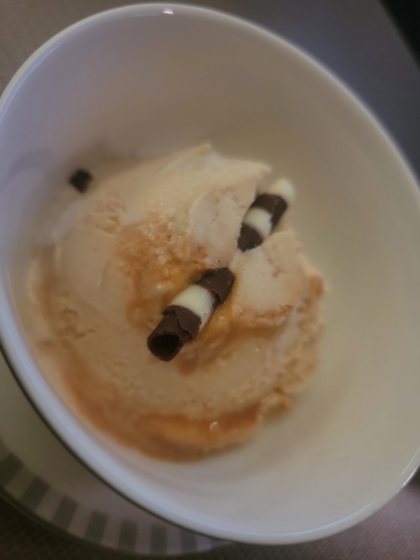 a bowl of ice cream with chocolate sticks