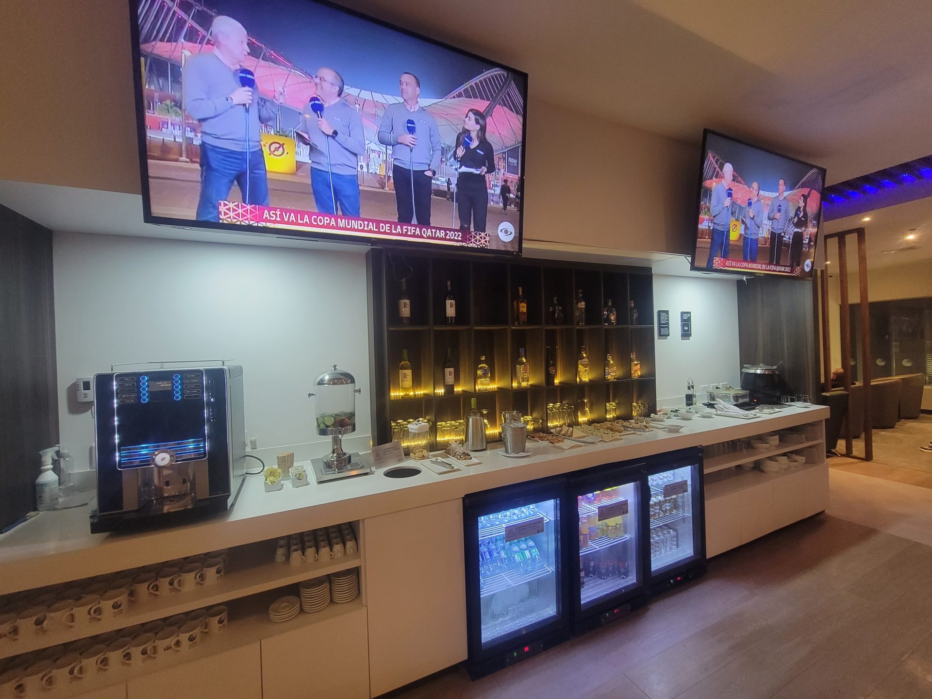 a room with a bar with a television and drinks