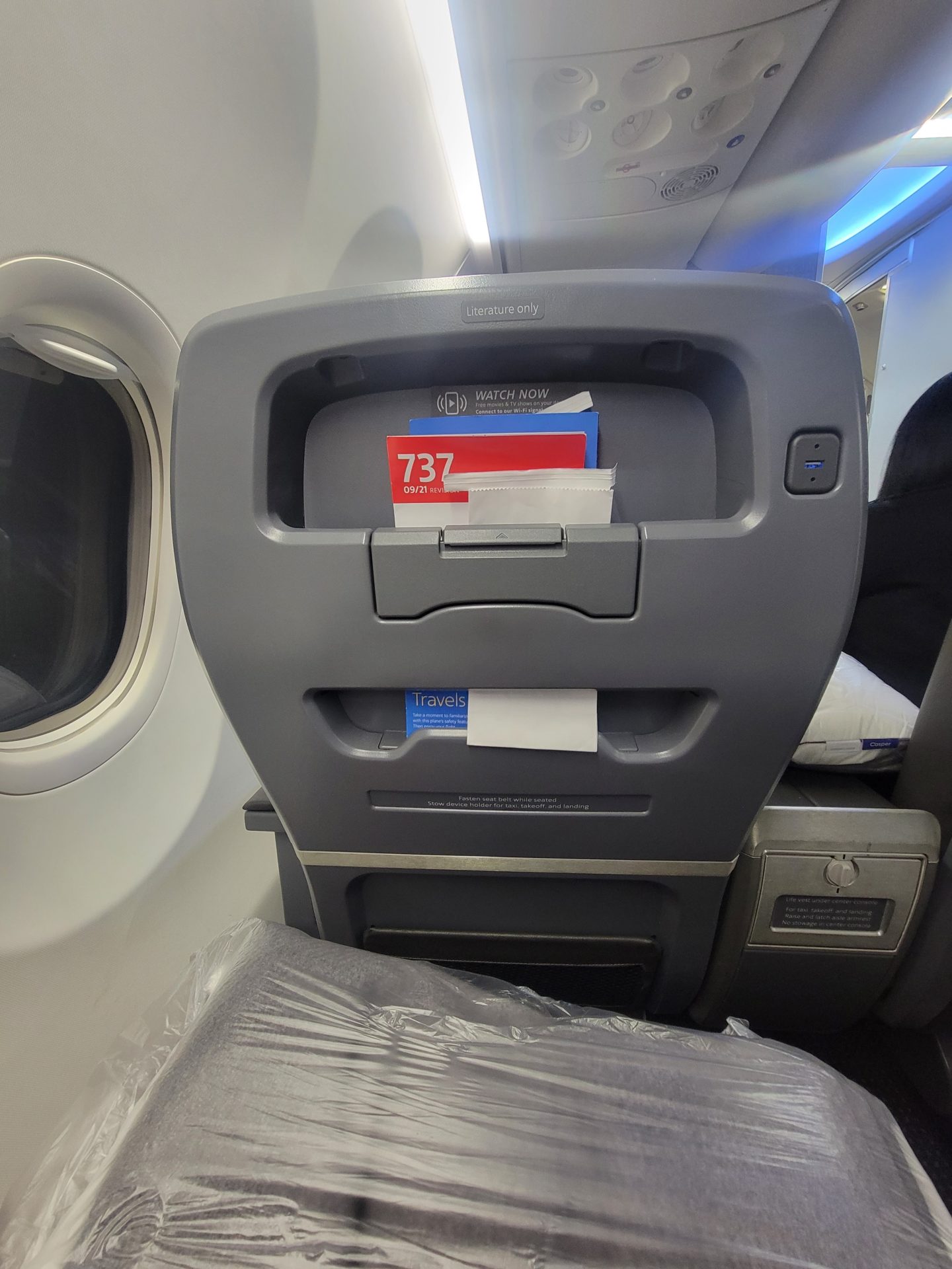 an airplane seat with a shelf
