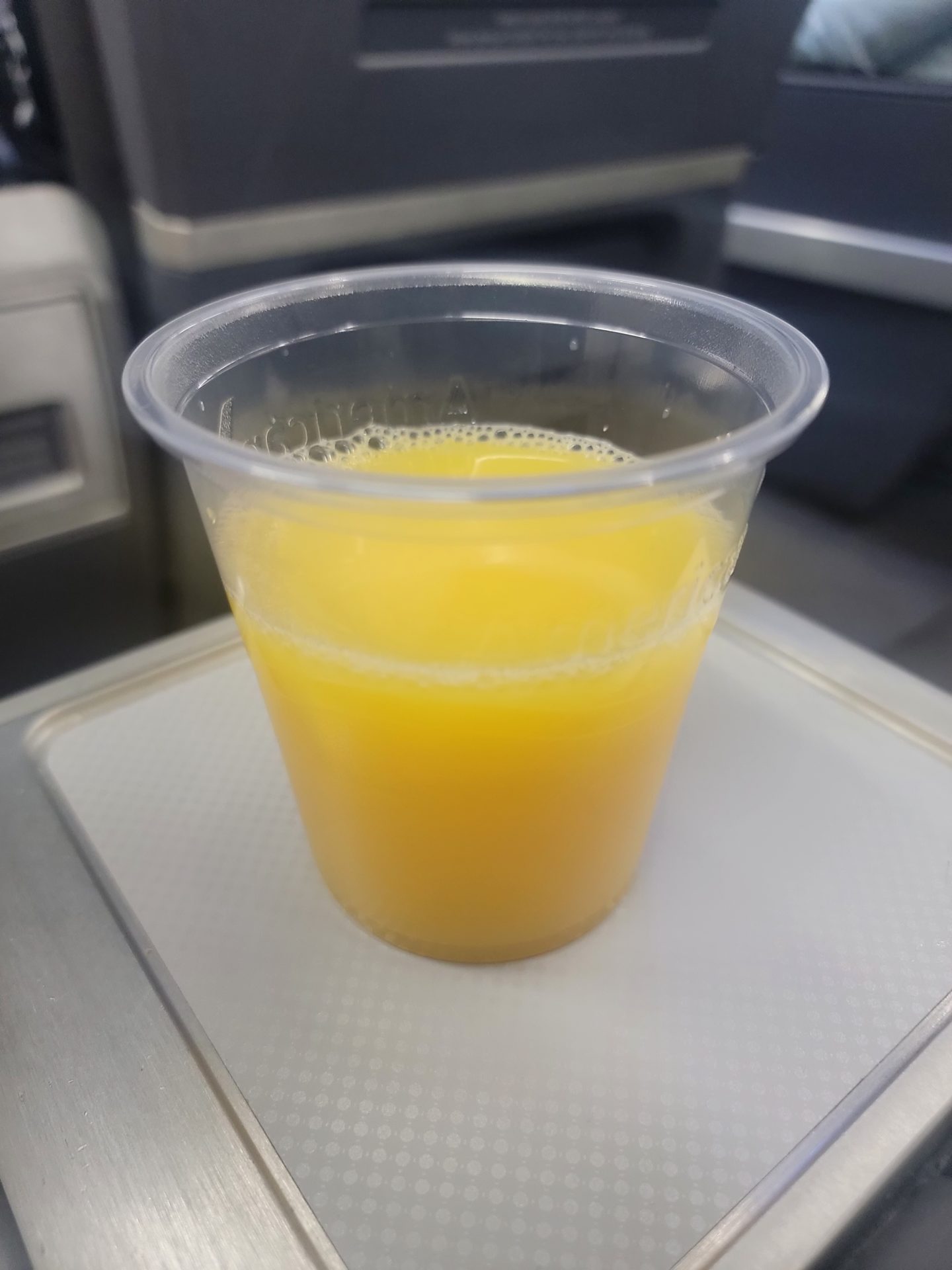 a plastic cup of orange juice