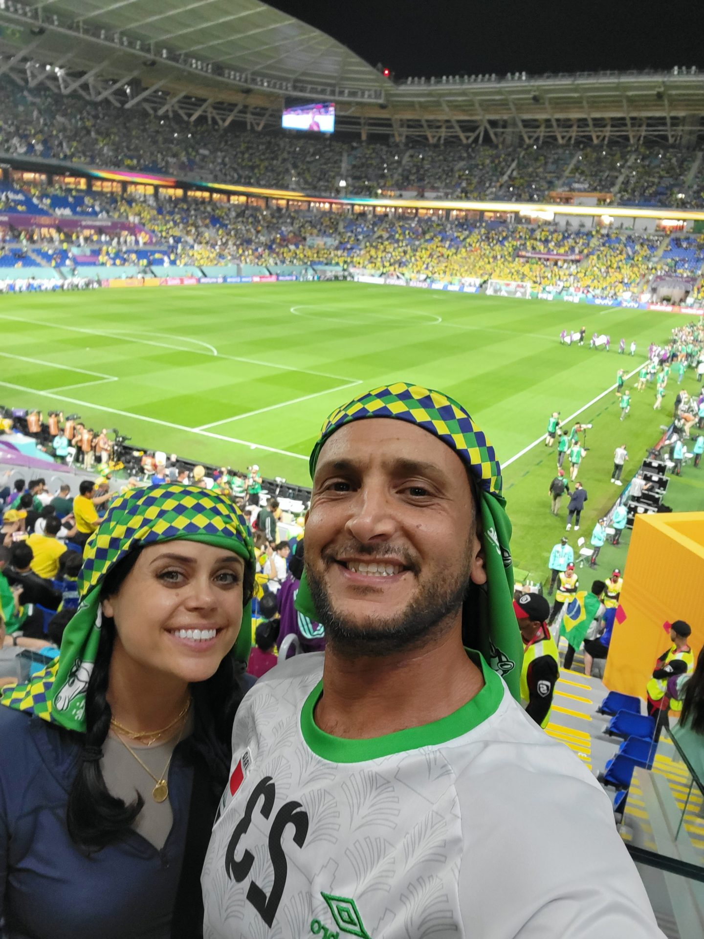 a man and woman taking a selfie in a stadium