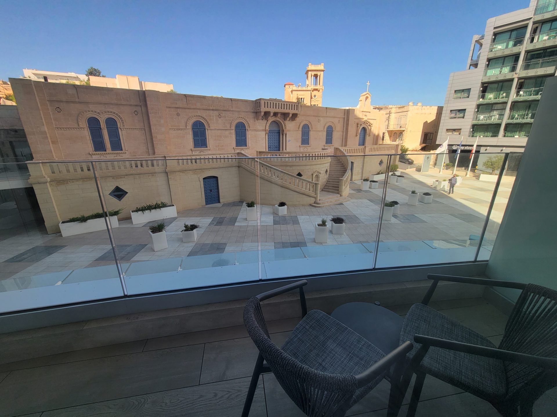 a balcony with a glass wall and a building