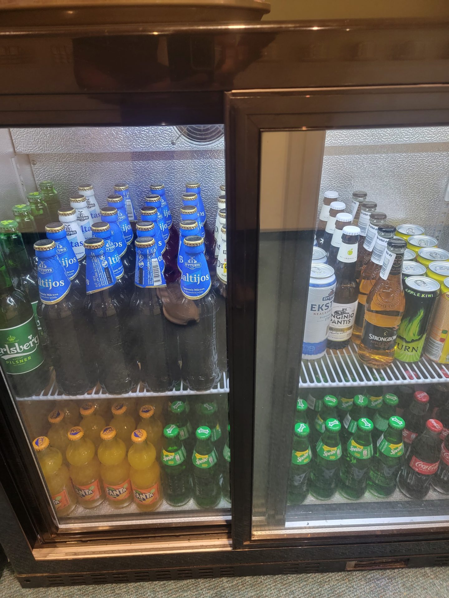 a refrigerator with bottles of beer and soda