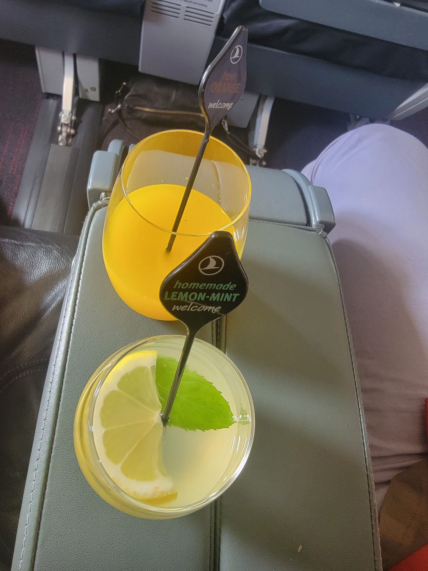 a glass of lemonade and a lemon slice on a table