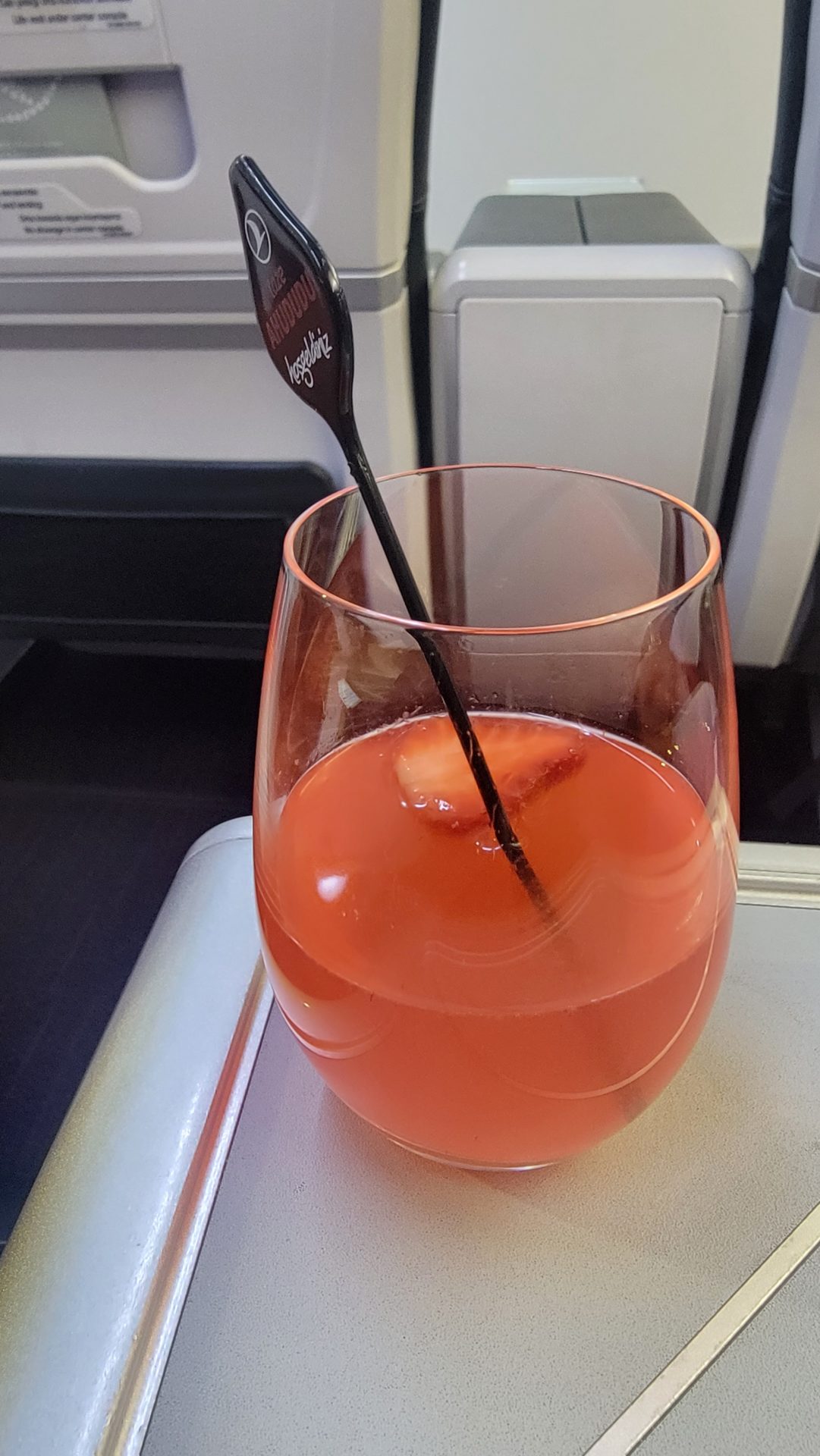 a glass of pink liquid with a straw in it