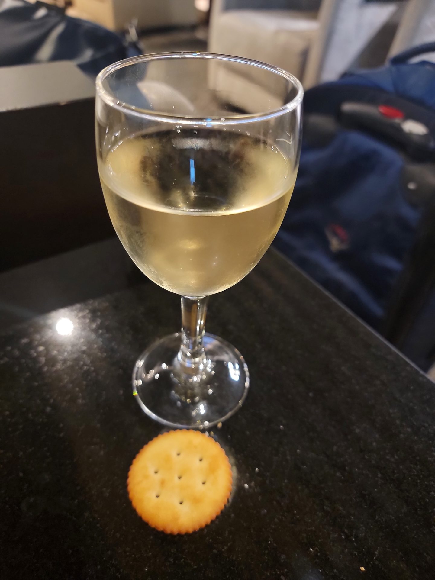 a glass of wine and a cracker on a table