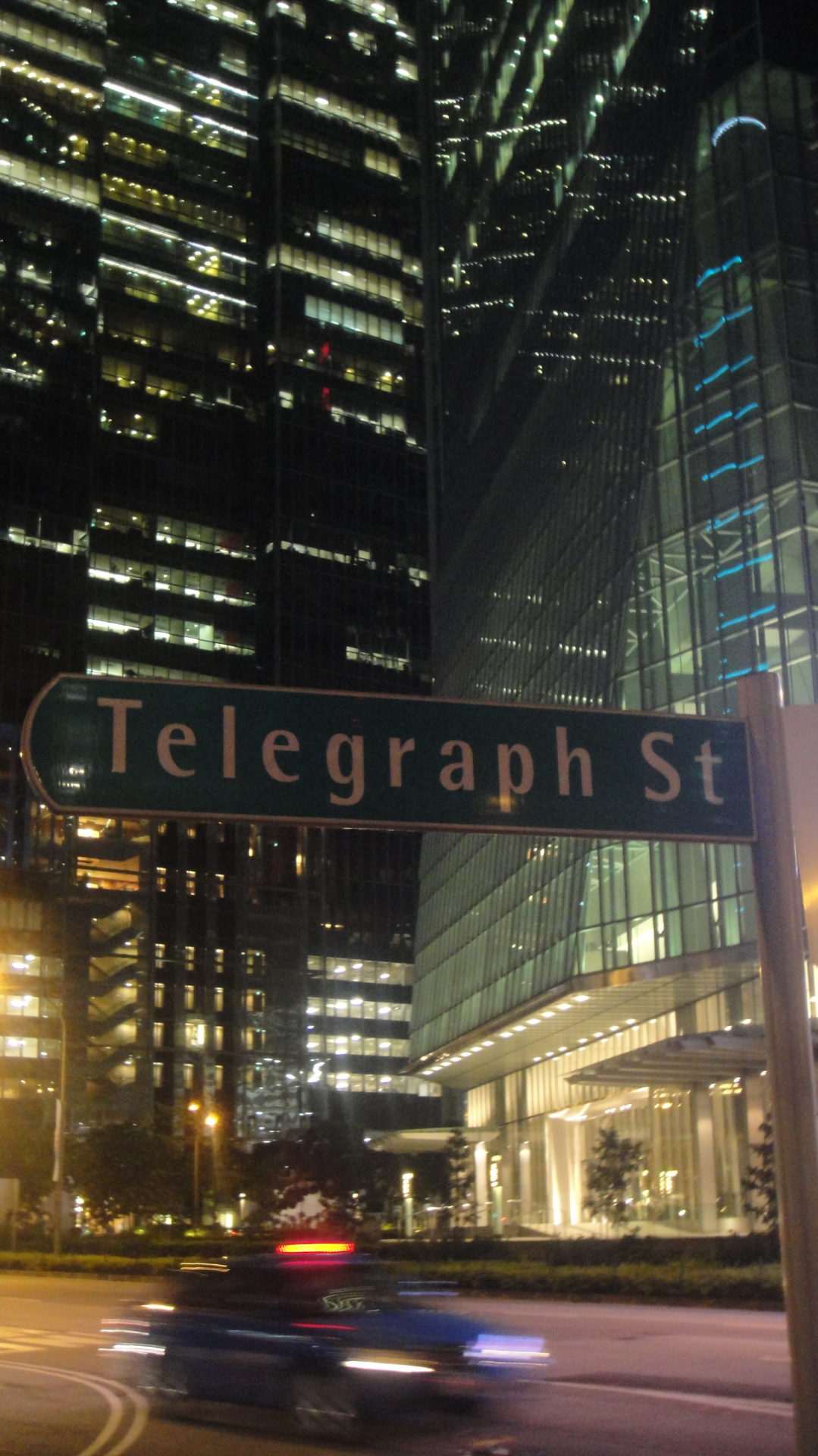 a street sign in front of a skyscraper