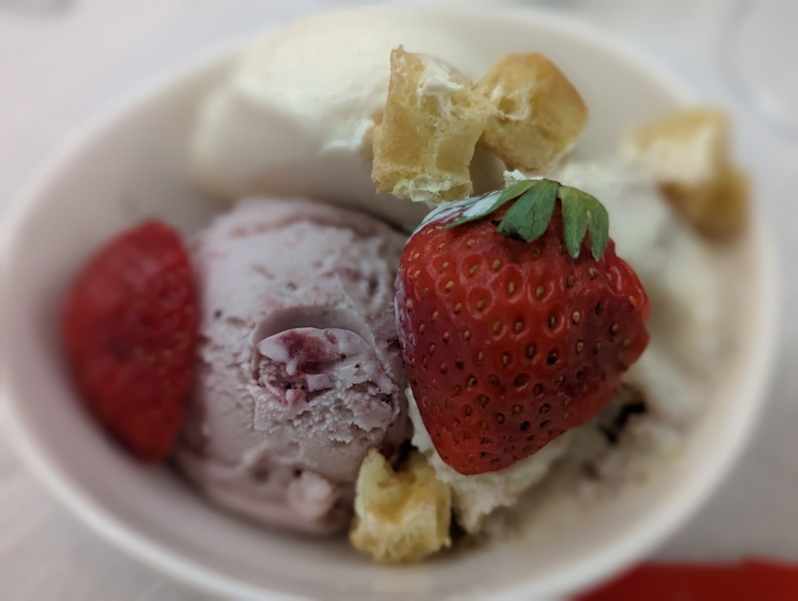 a bowl of ice cream and strawberries