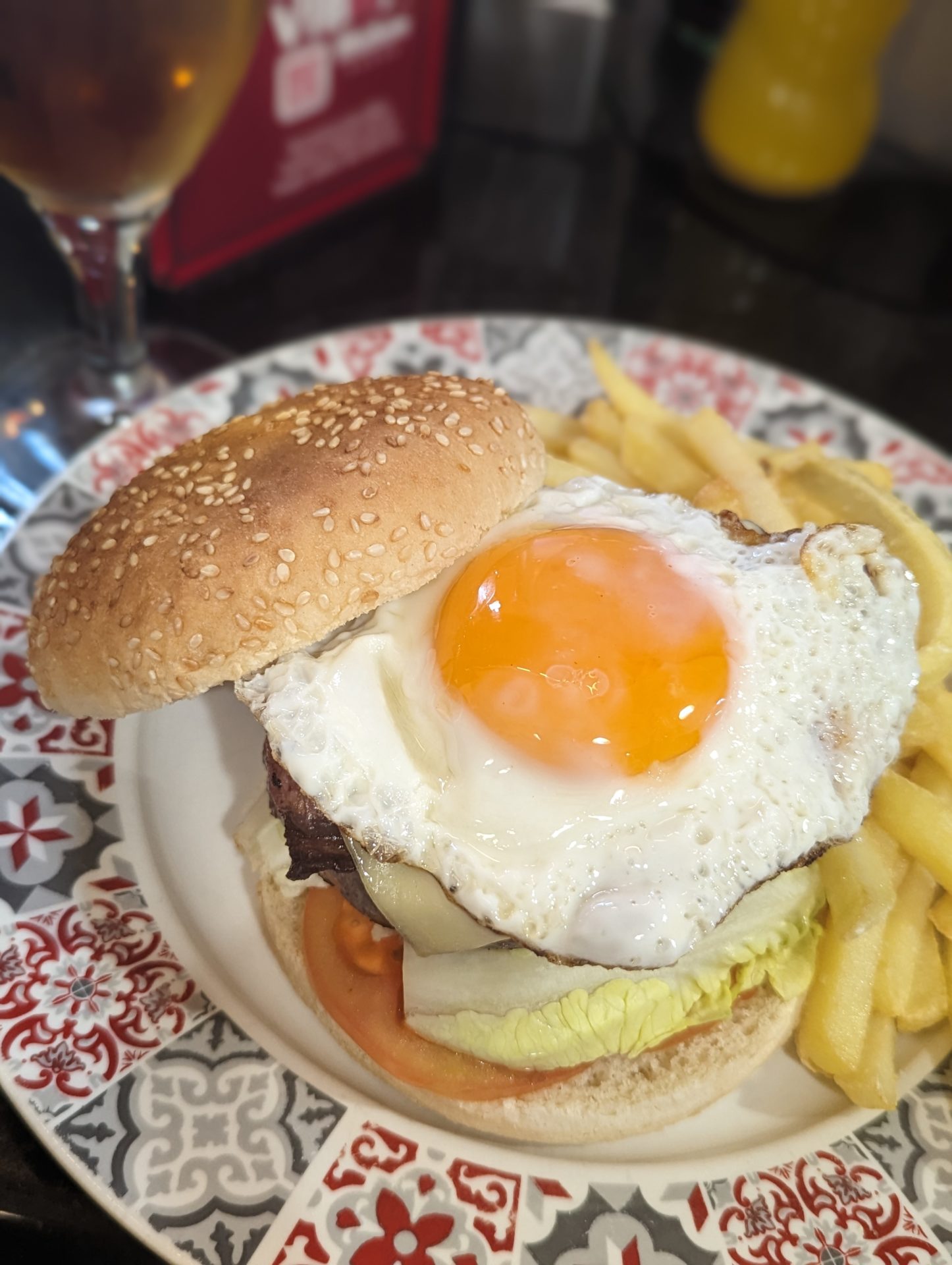 a burger with a fried egg and fries on a plate