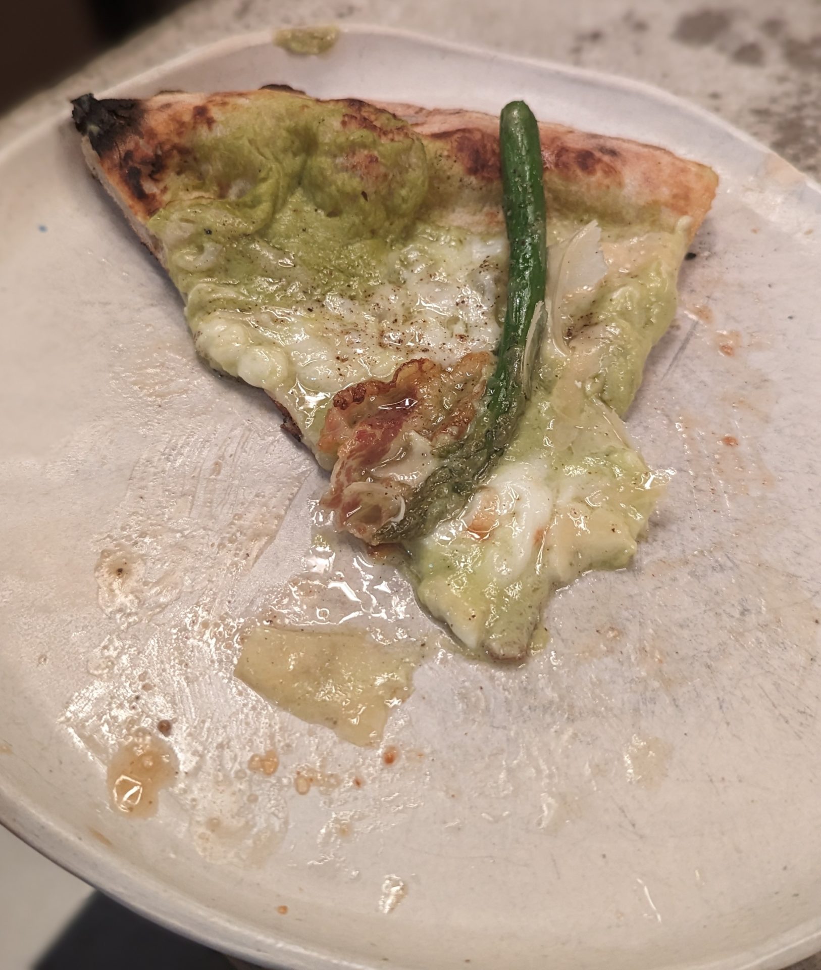 a pizza with a green pepper on a plate