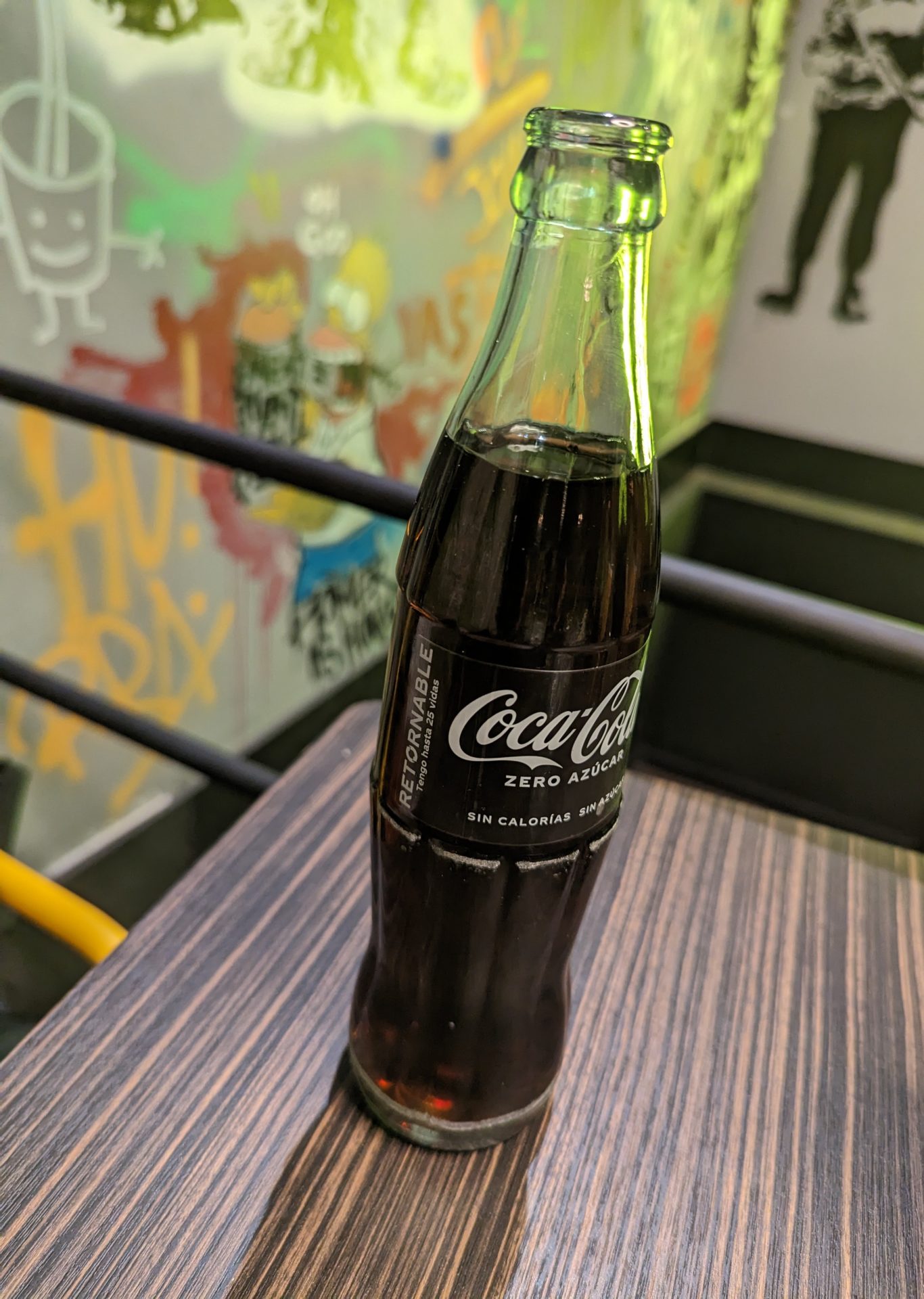a glass bottle of soda on a table
