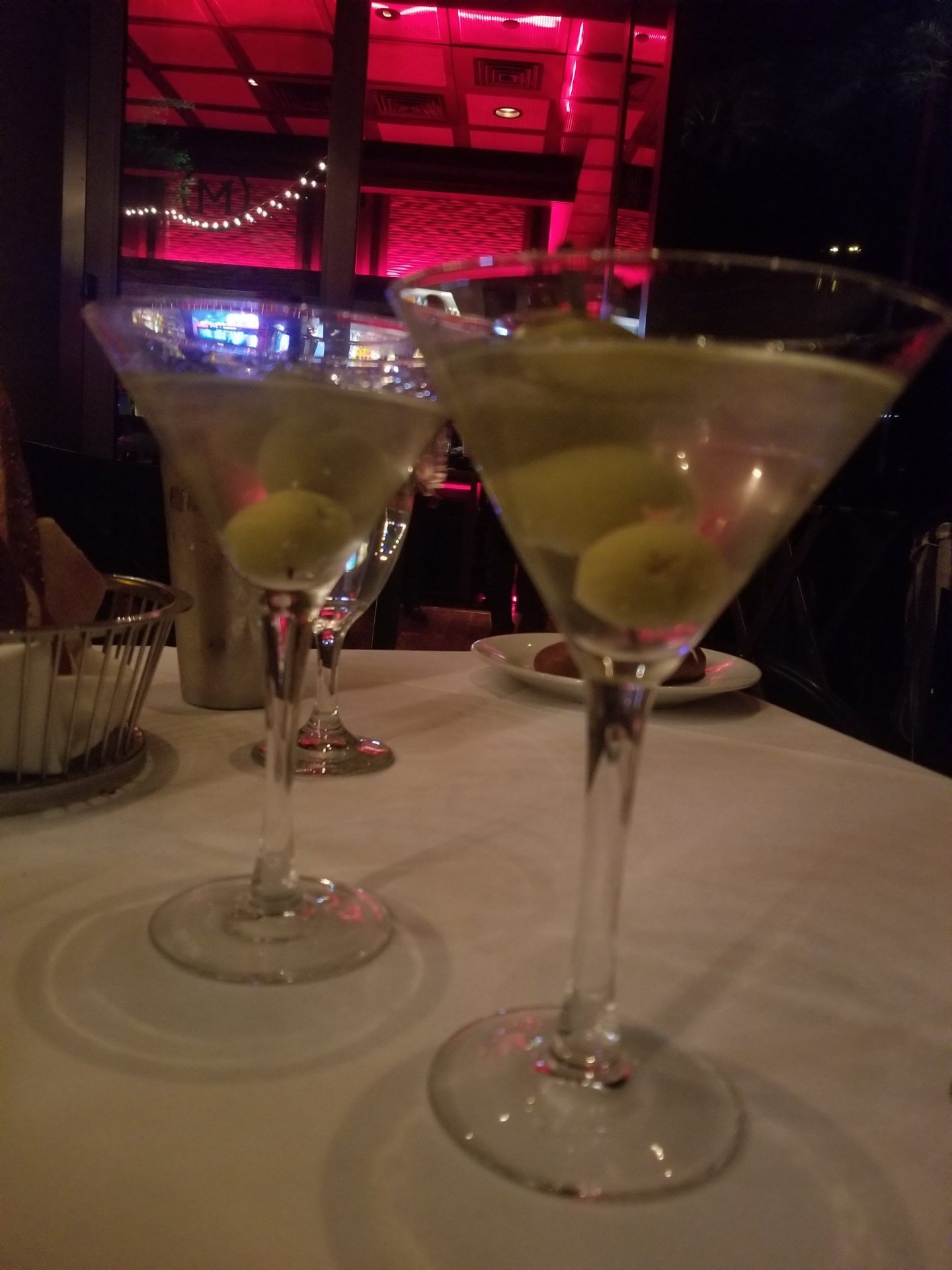 a group of martini glasses with olives on a table