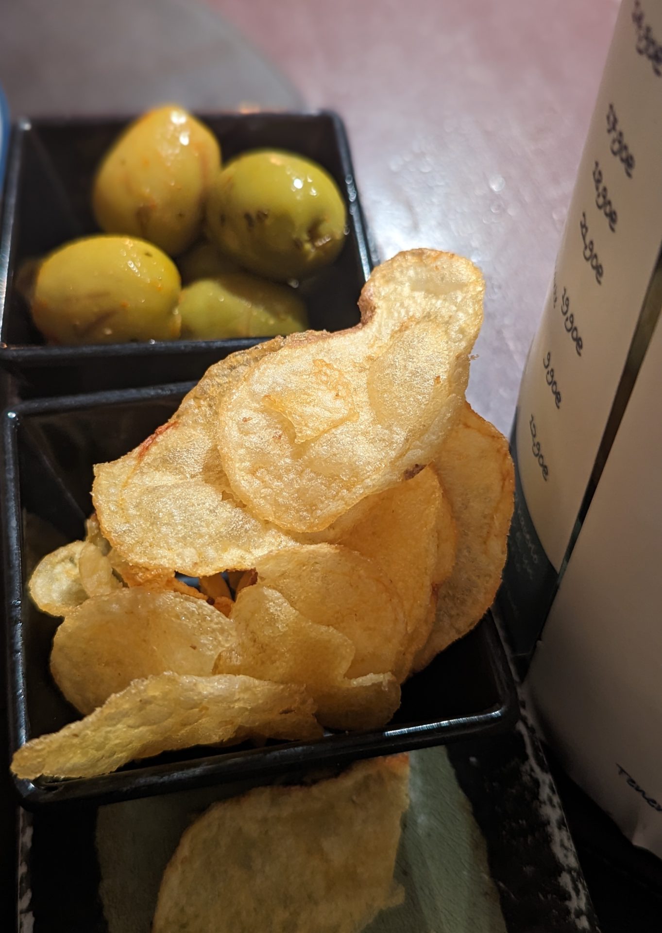 a bowl of potato chips and olives