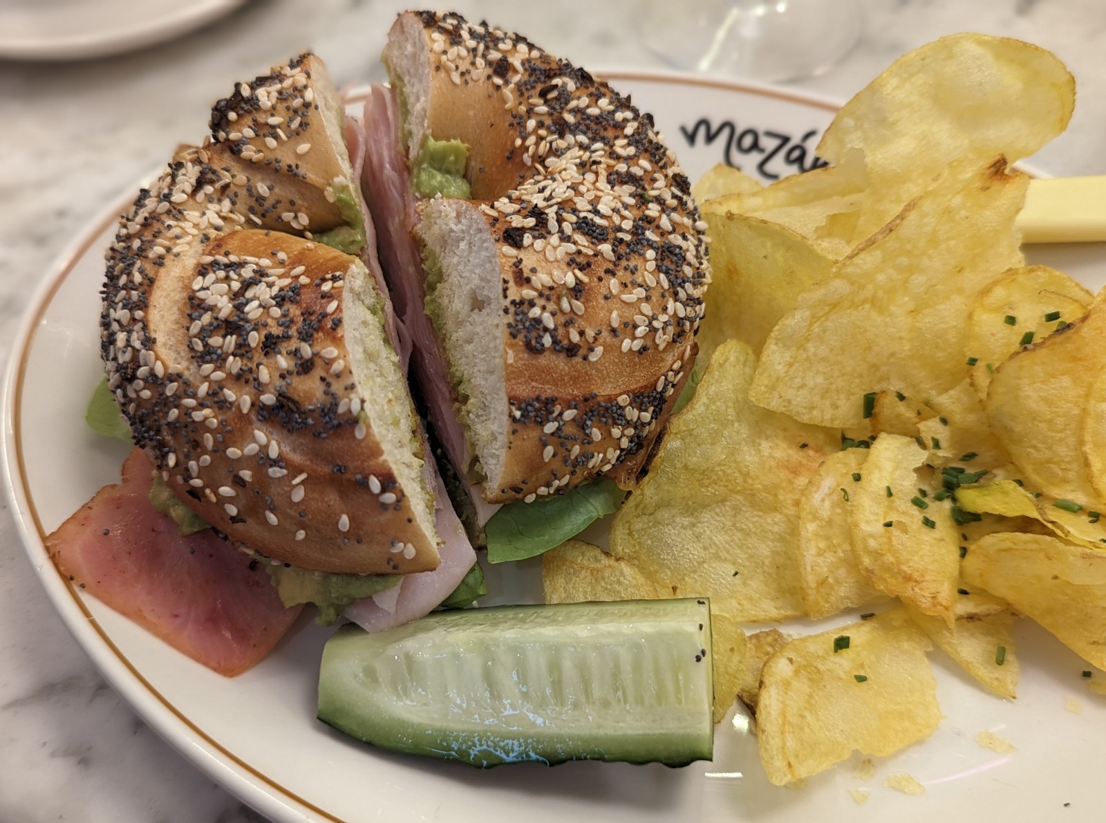 a bagel sandwich and chips on a plate