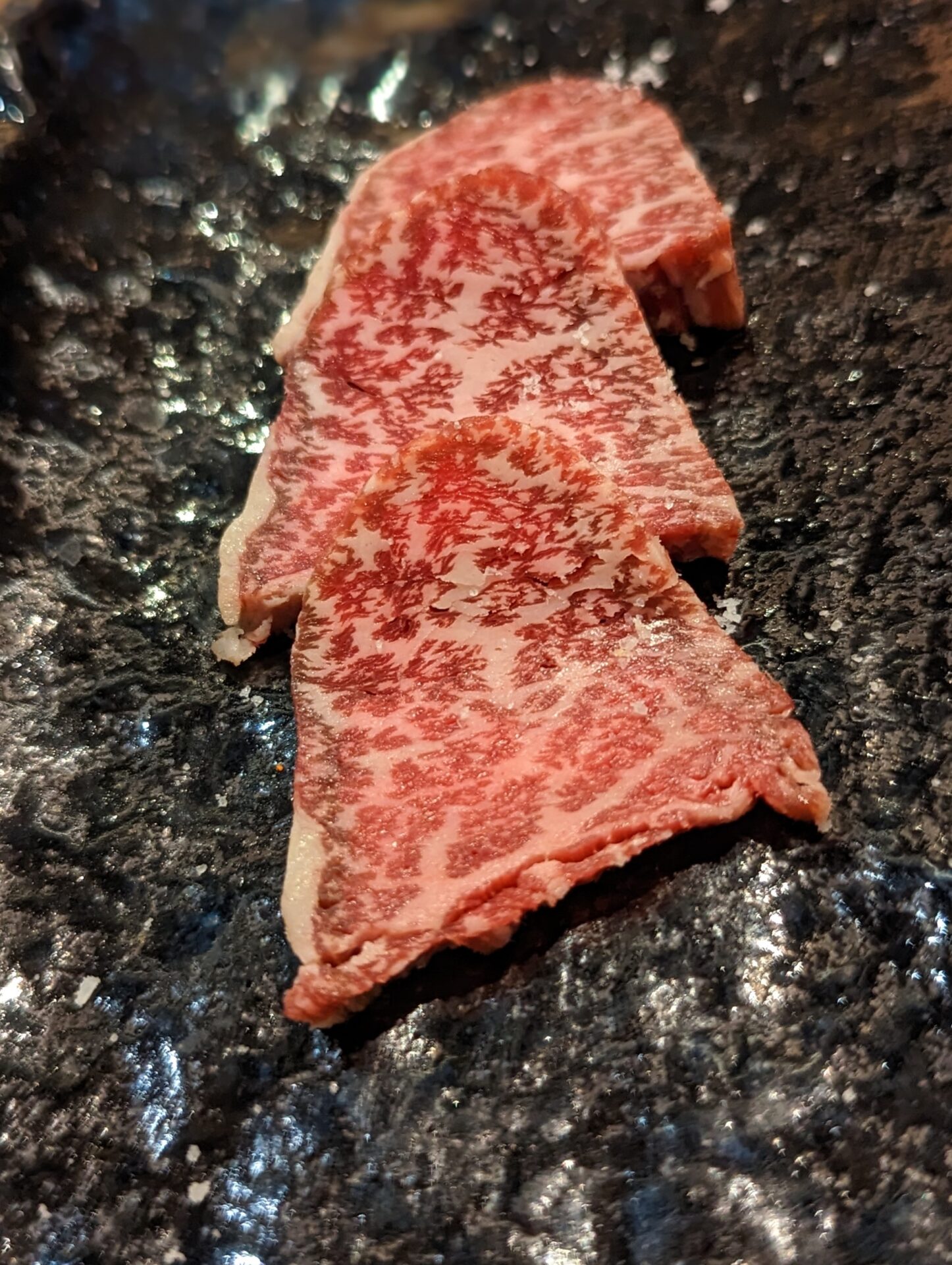 a group of raw meat on a black surface