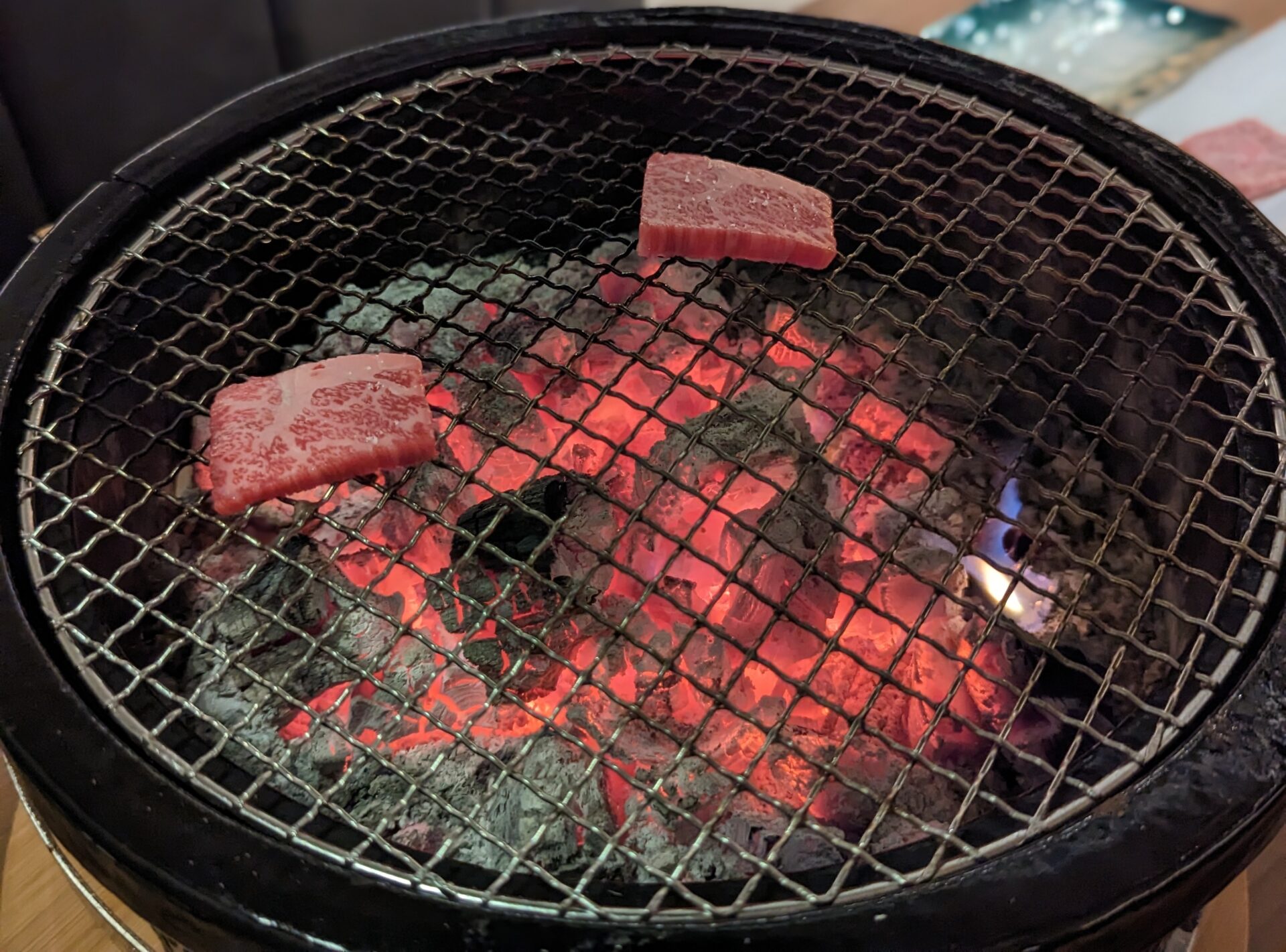 meat on a grill with a fire