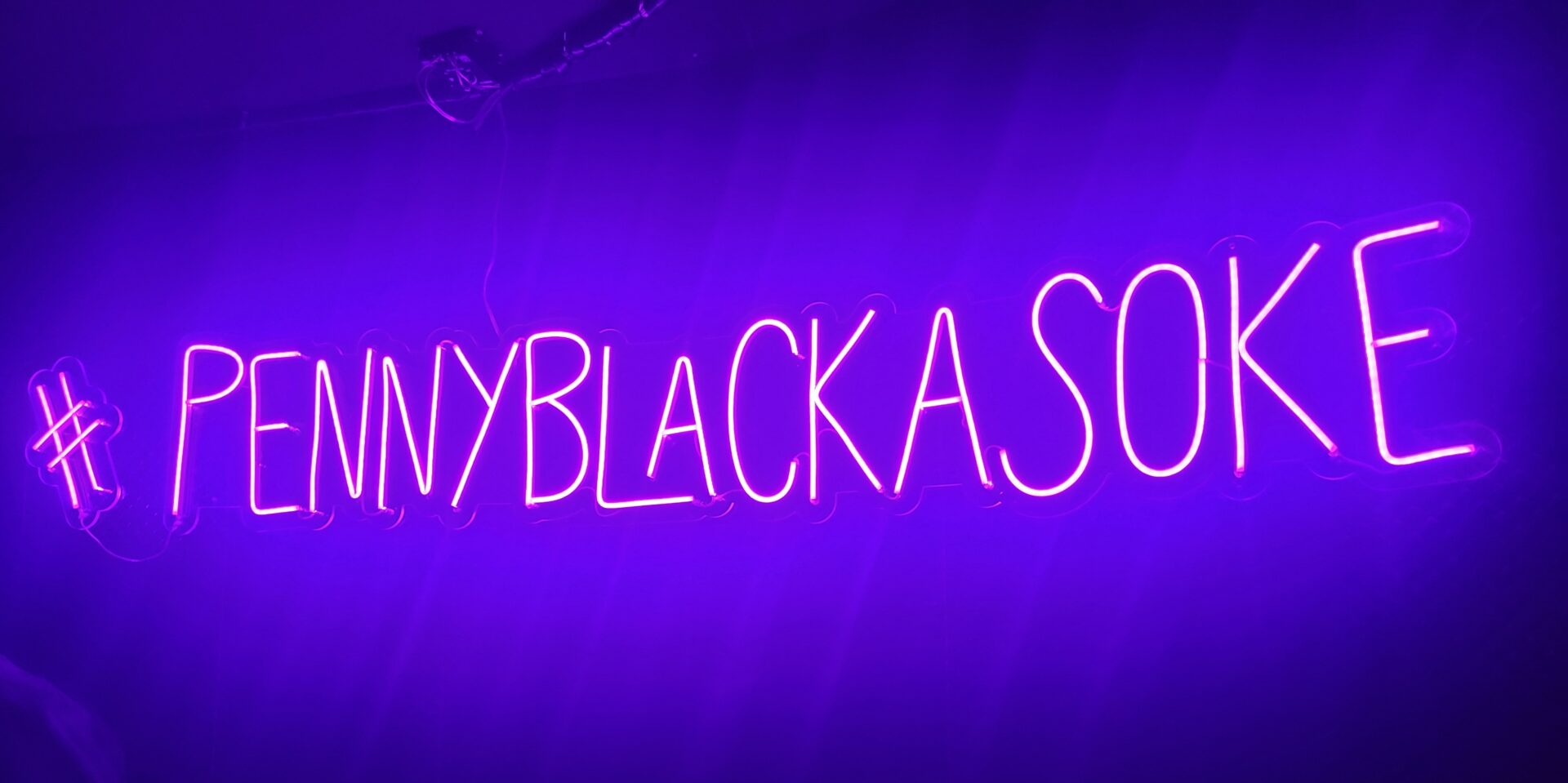 a purple neon sign with text