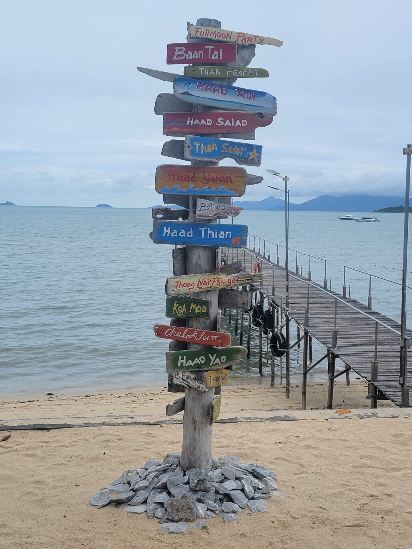 a sign post with many different colored signs on it