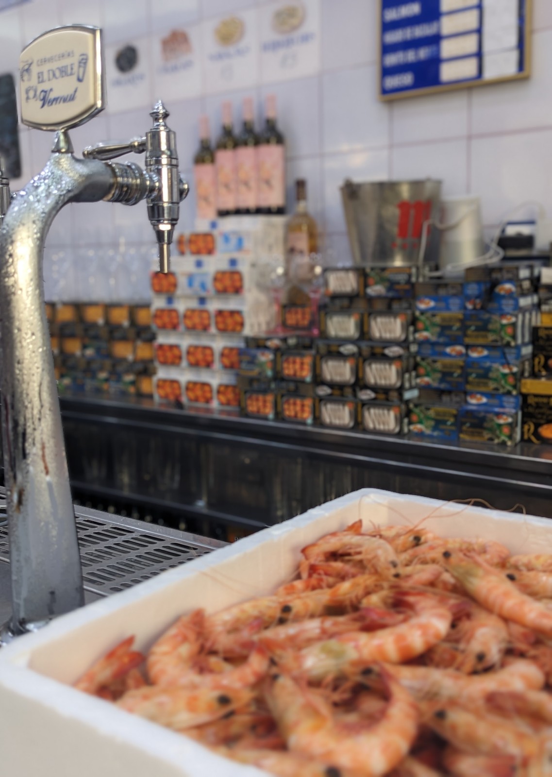 a tray of shrimp in front of a beer tap
