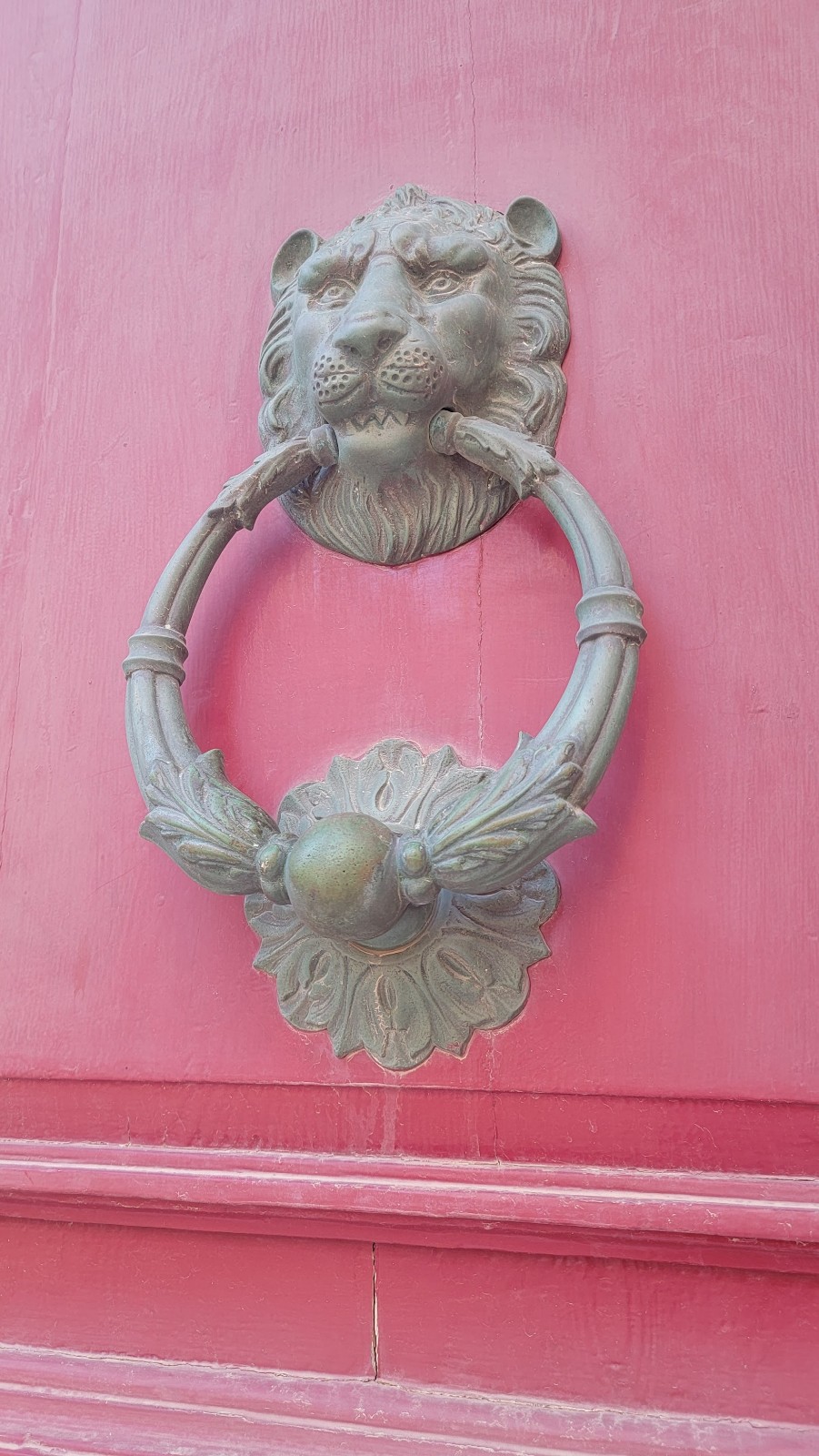 a door knocker on a pink wall