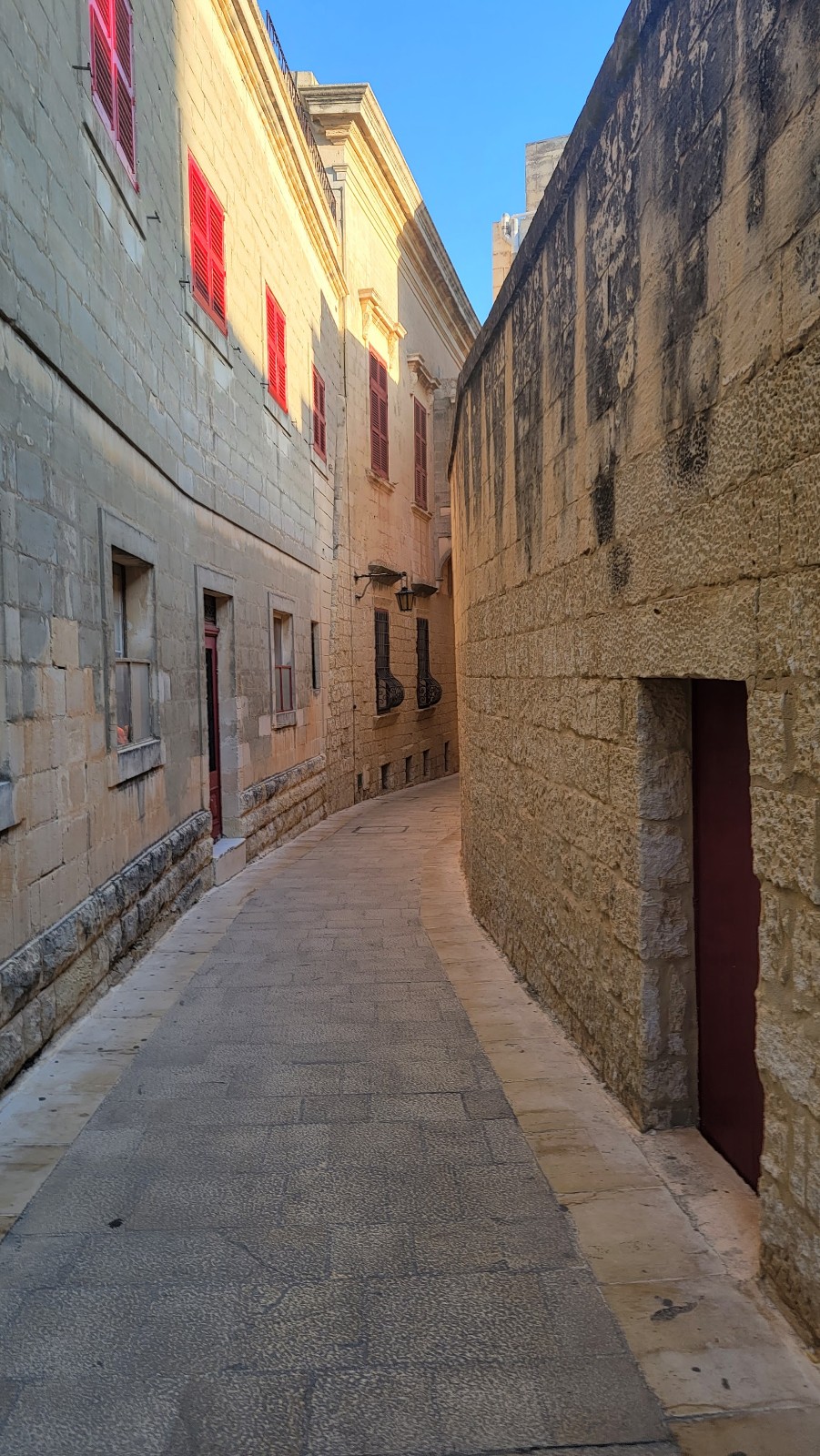 a narrow street between stone buildings