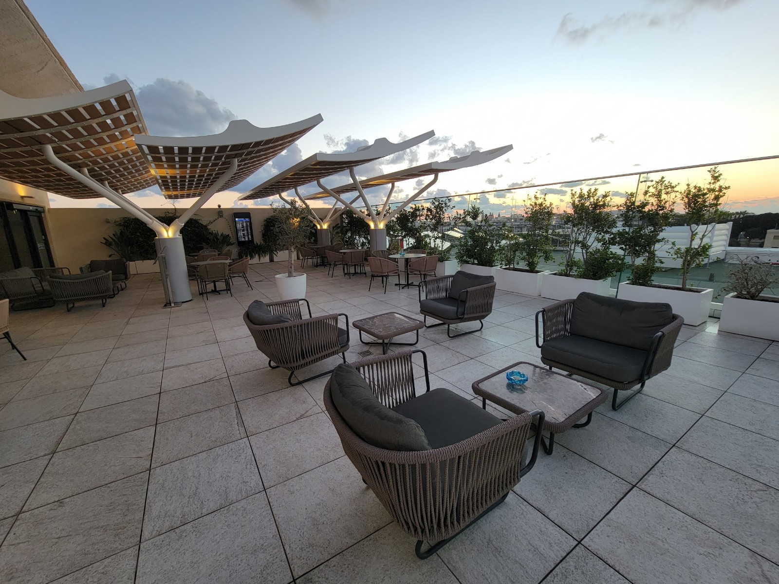 a patio with chairs and tables on a rooftop
