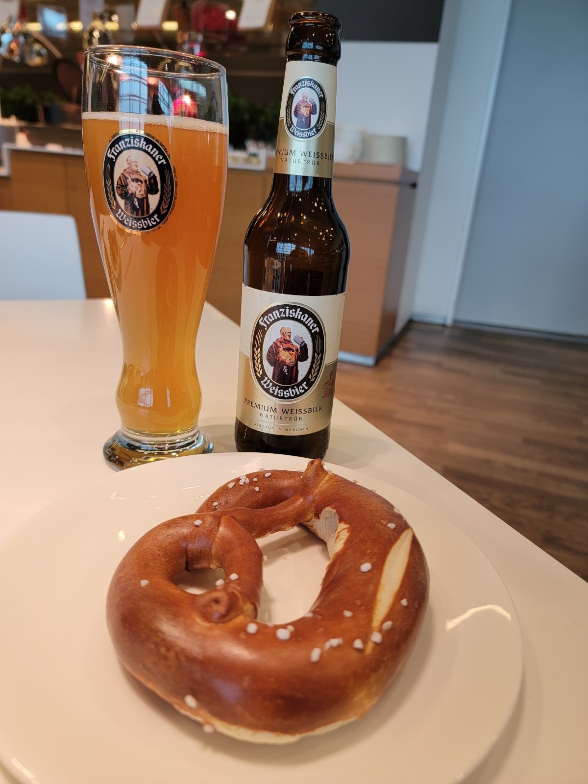 a pretzel and two beer bottles on a table