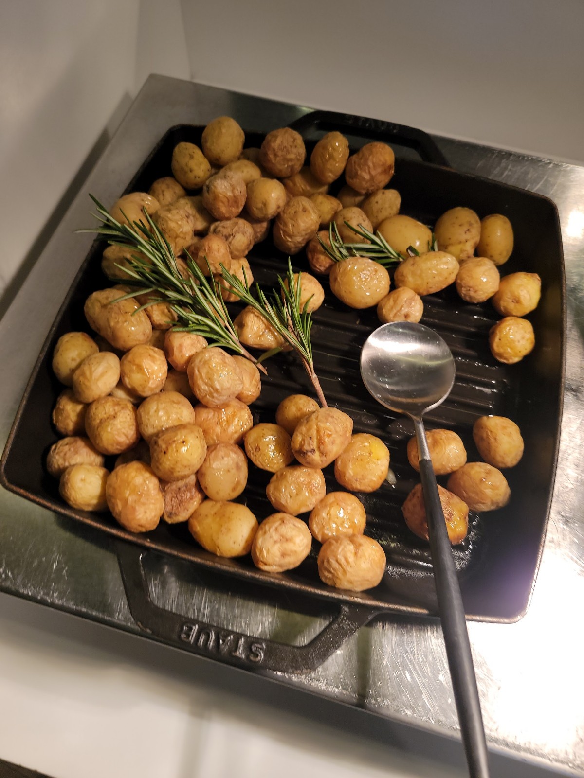 a pan with potatoes and a spoon