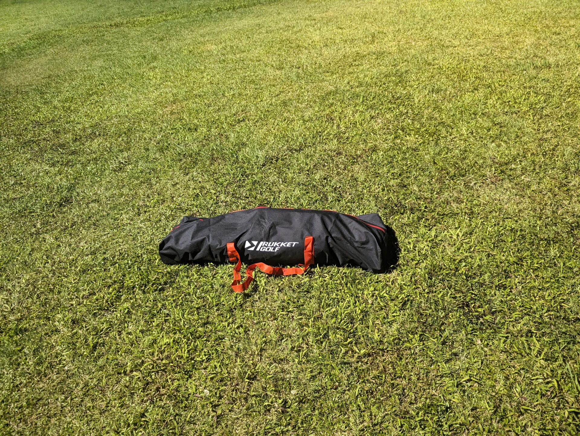 a black and red bag on grass