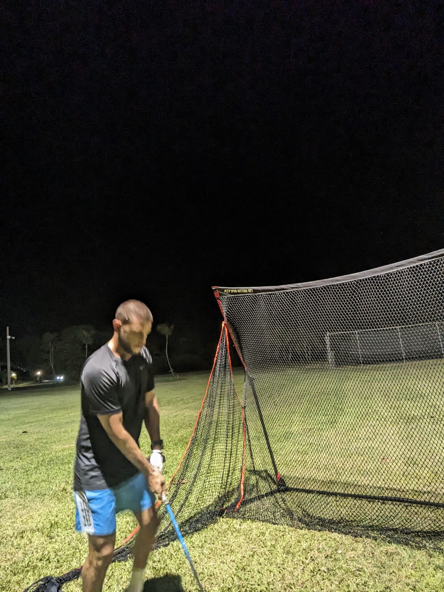 a man holding a bat in front of a net