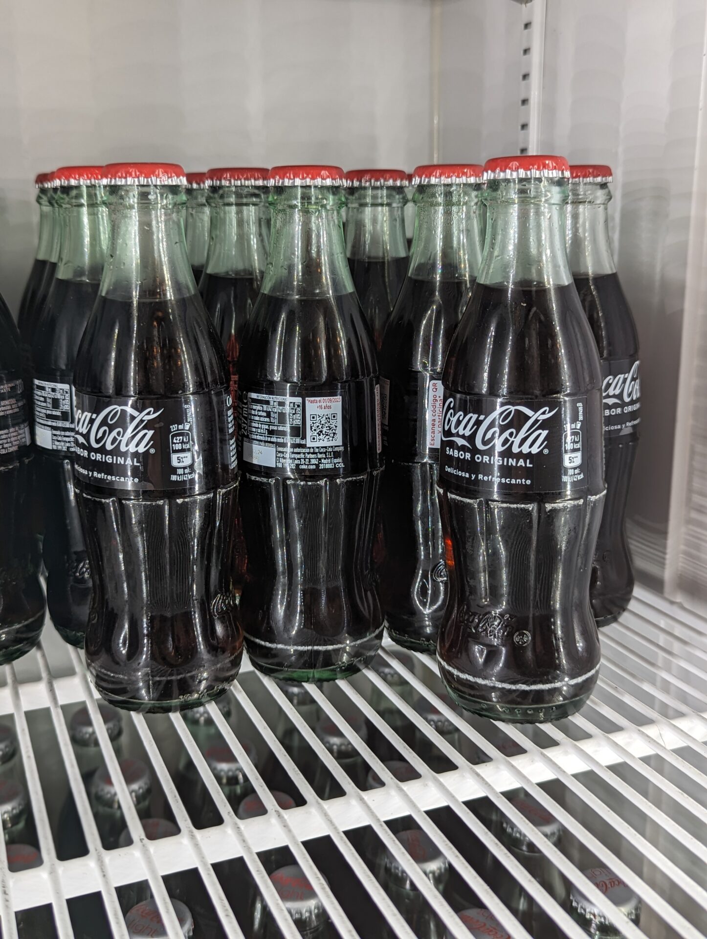 a group of bottles of soda on a shelf