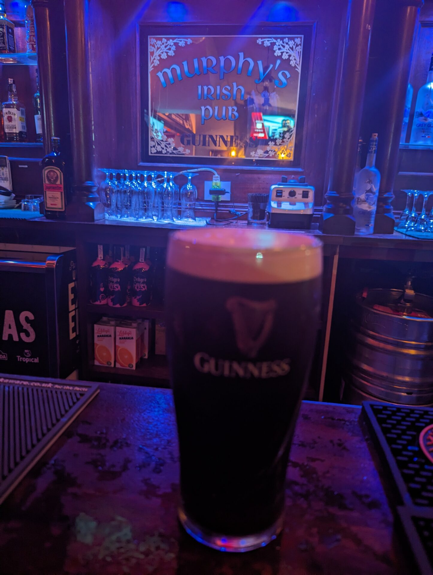 a glass of beer on a bar