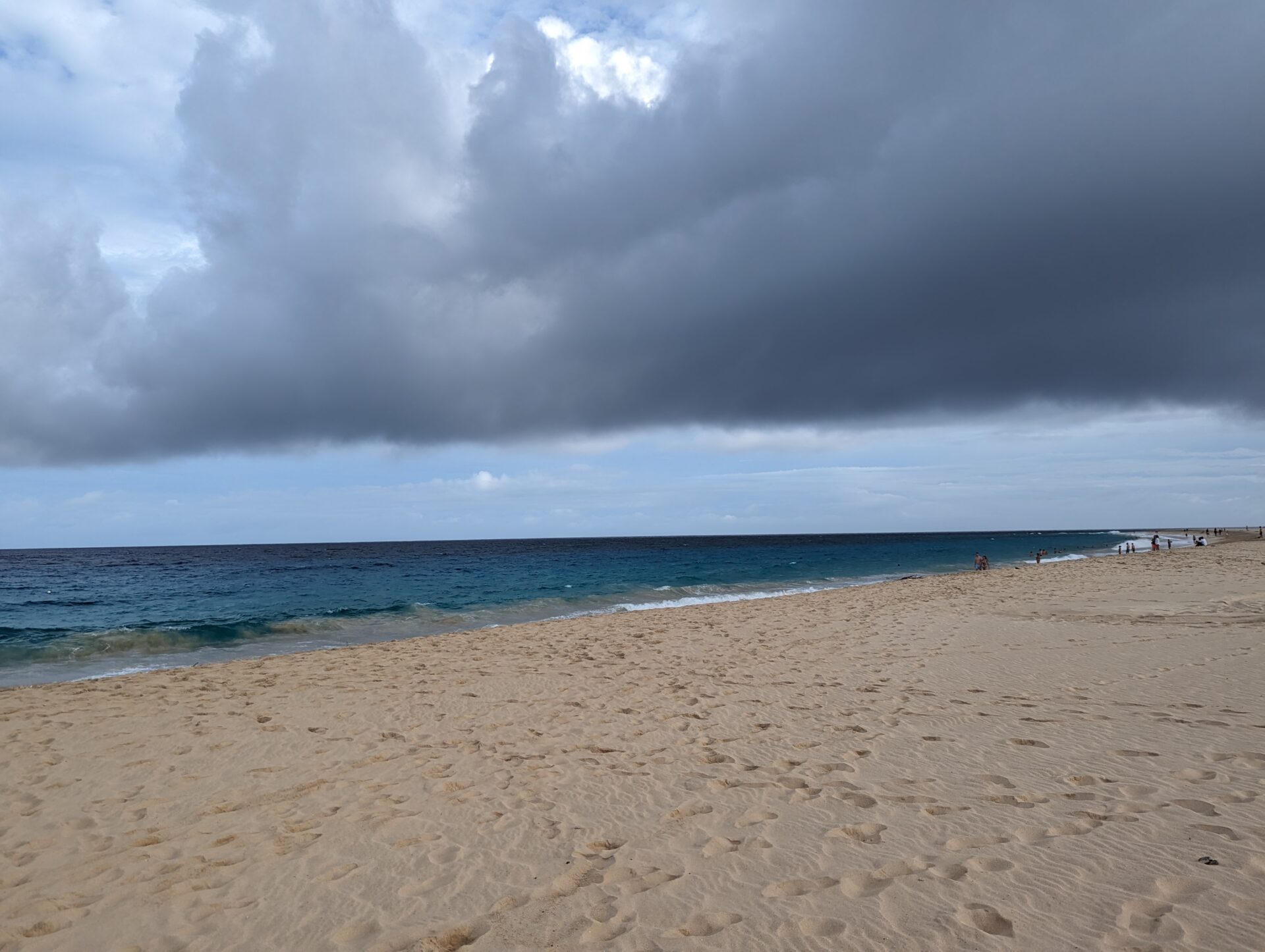 a beach with a body of water and clouds