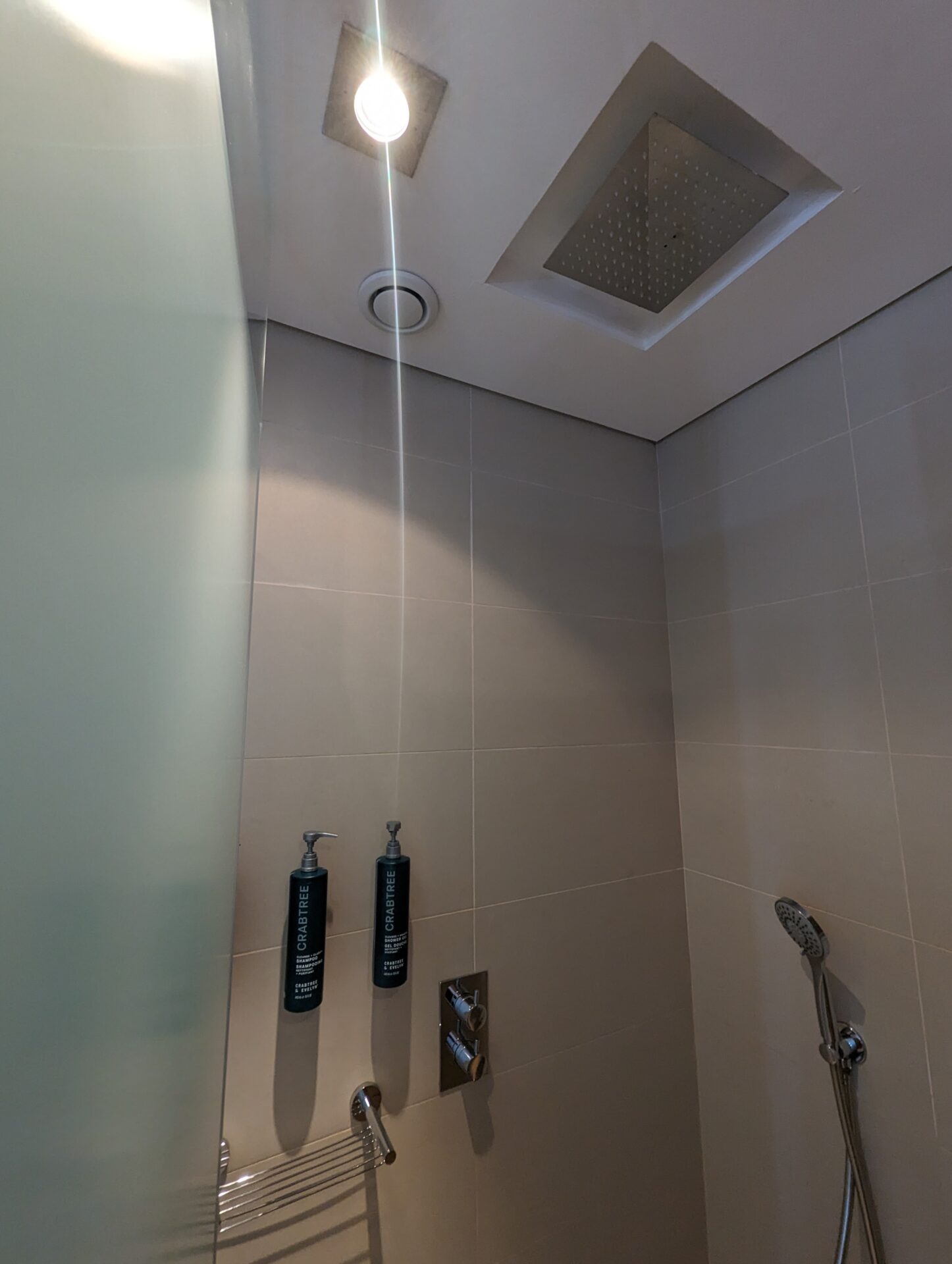 a shower with a light coming from the ceiling