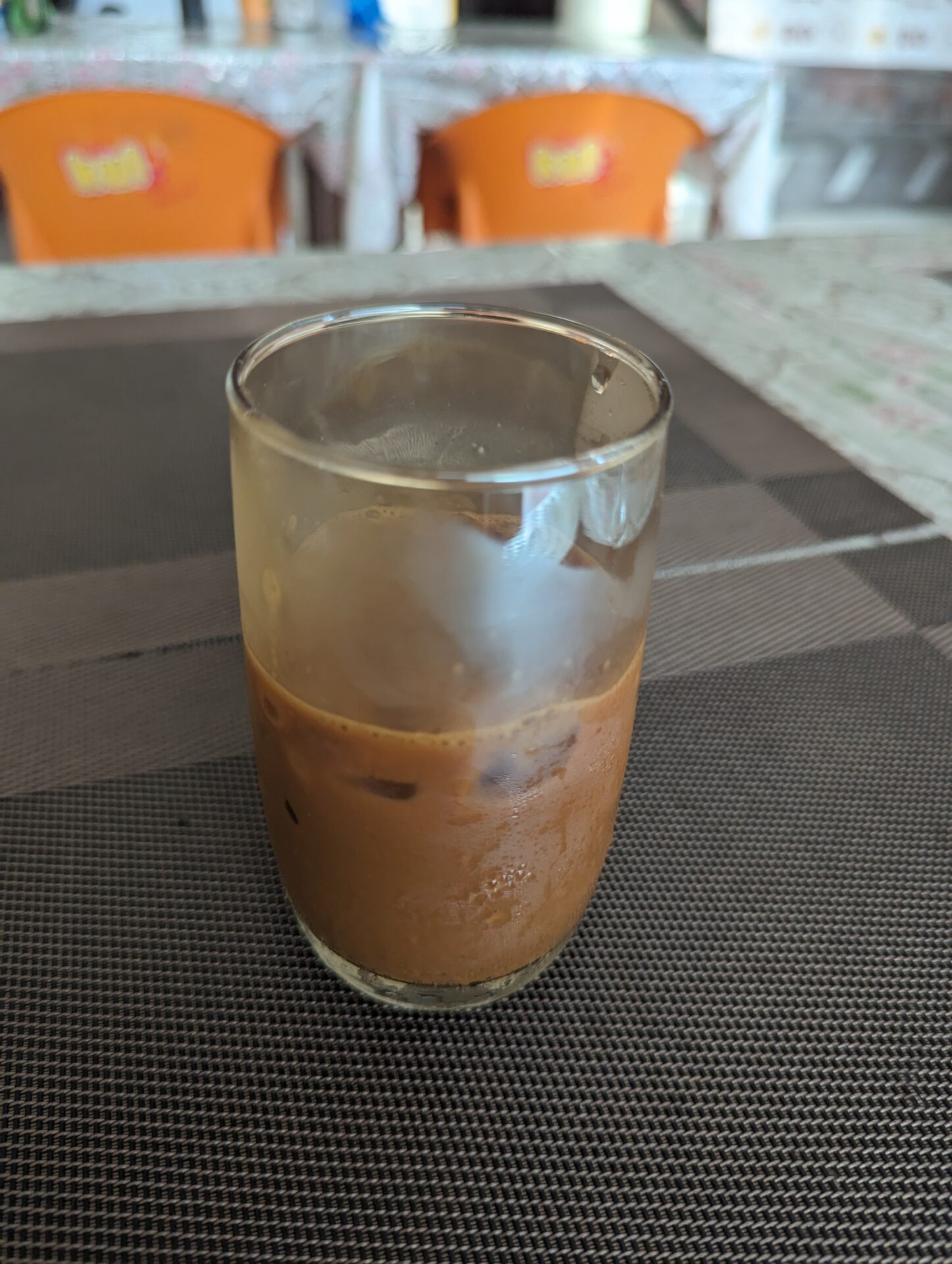 a glass of brown liquid on a table
