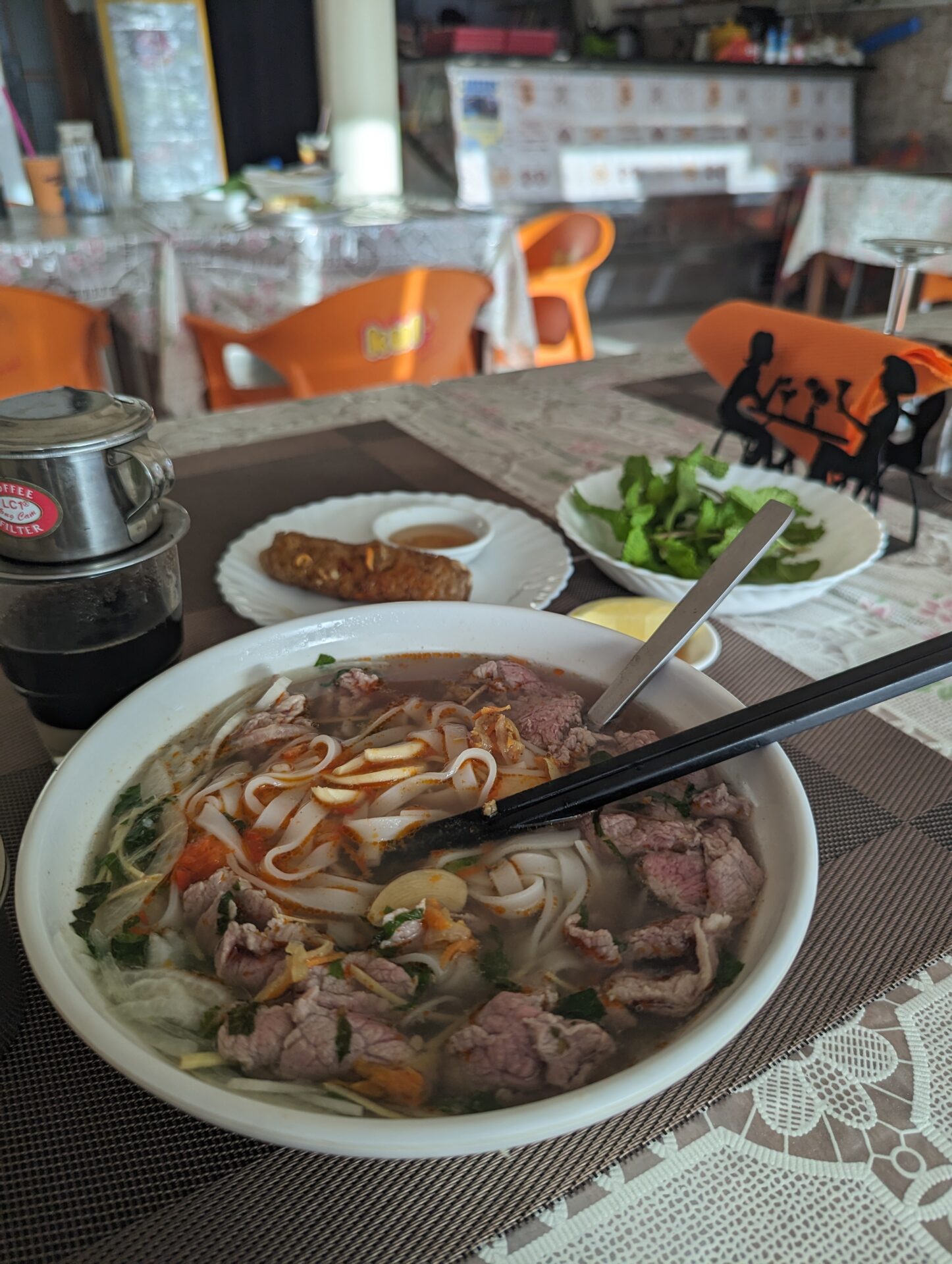 a bowl of soup with meat and noodles and chopsticks