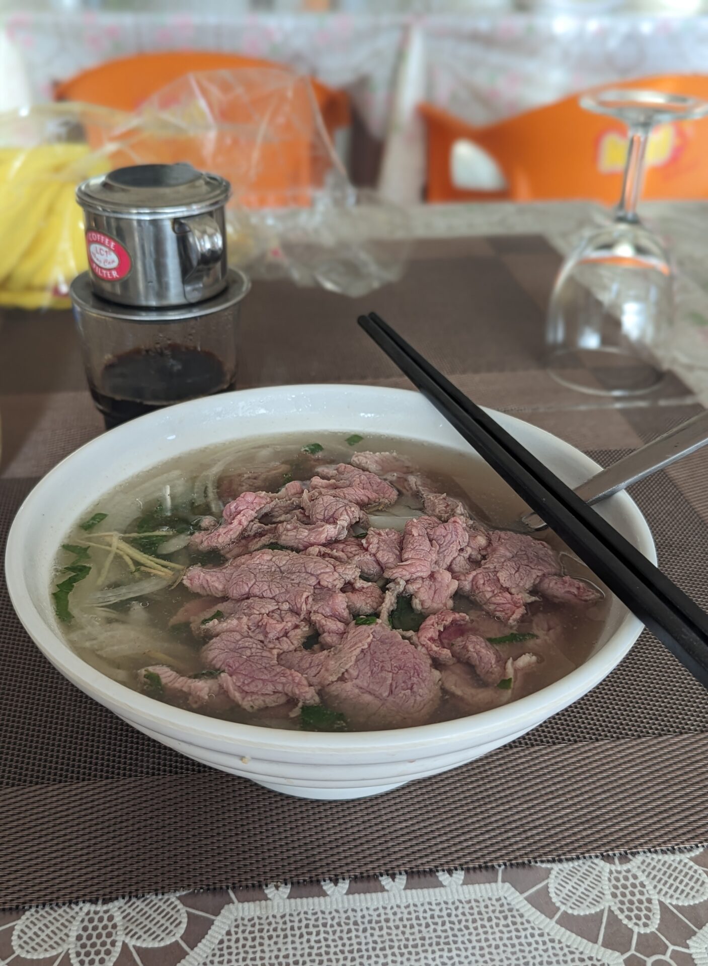 a bowl of soup with meat and chopsticks