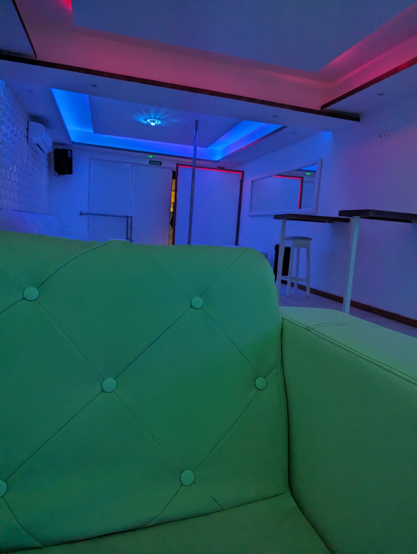 a green couch in a room with lights