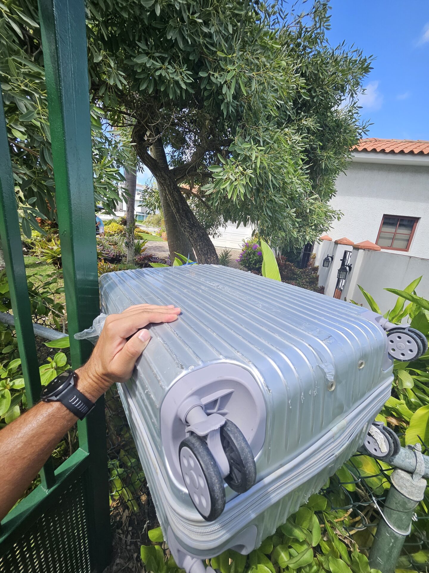 a hand holding a silver suitcase